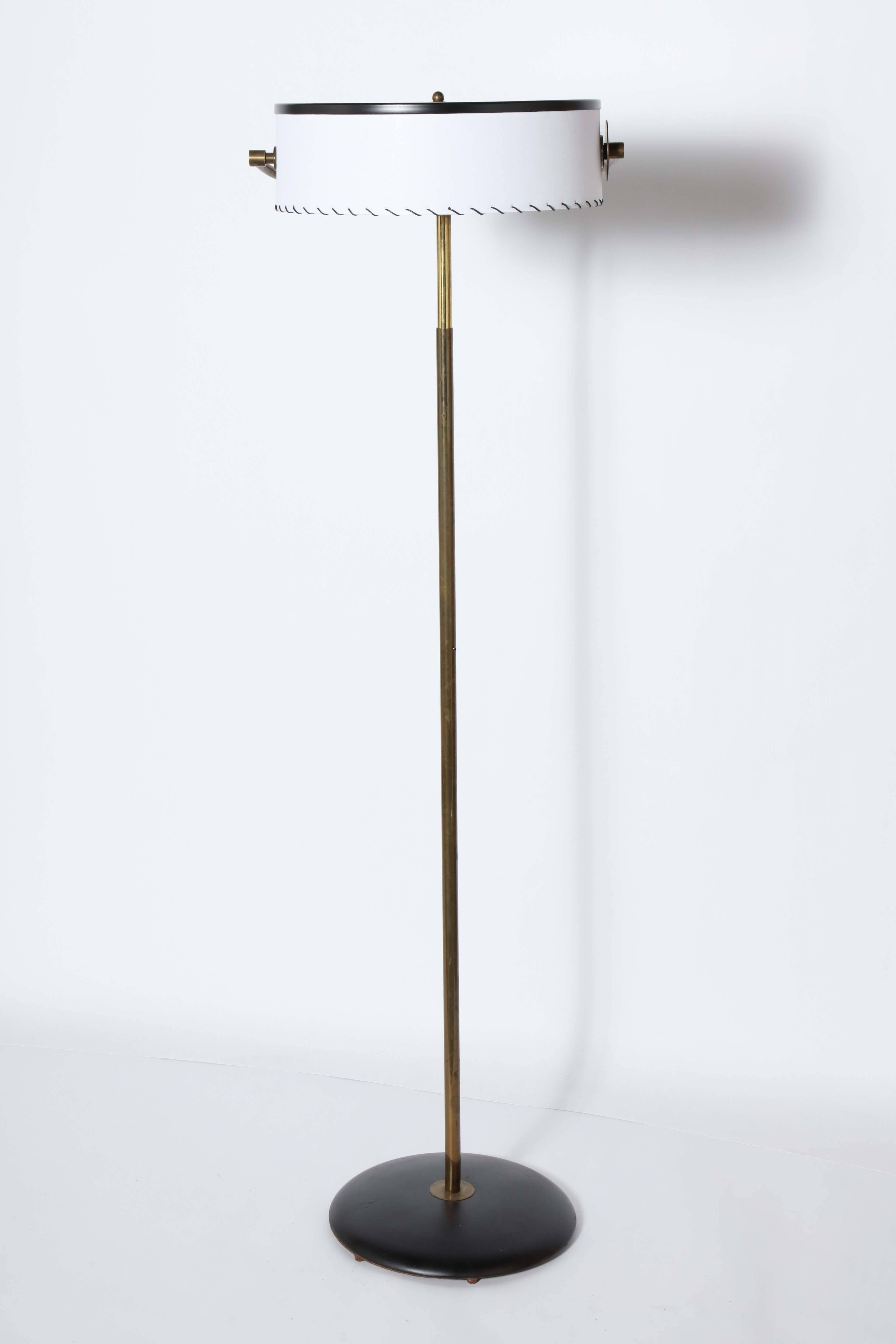 Kurt Versen Adjustable Bronze and Black Enamel Reading Floor Lamp, early 1930's. Featuring an adjustable stem (56H-70H), handsome vintage patina and tilt shade in new White Parchment with Black Leather whipstitch detail (15D x 4.75H), circular Black