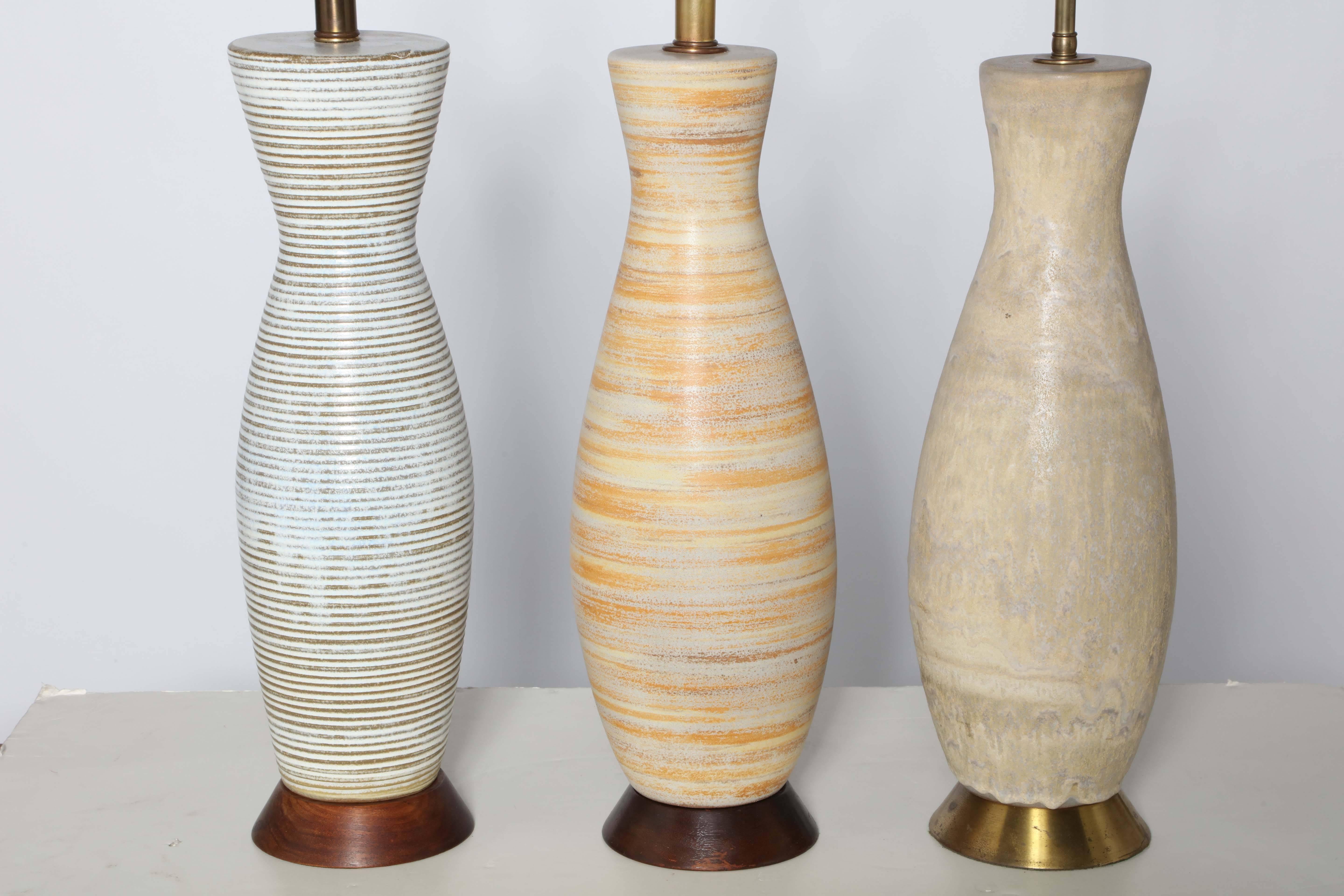 Three Tall Lee Rosen for Design Technics American Mid-Century Ceramic Table Lamps.  
Featuring corseted bottle form shapes, with natural, neutral soft palettes and Brass necks. Made in New York City. Rewired. Priced individually
LEFT: Incised