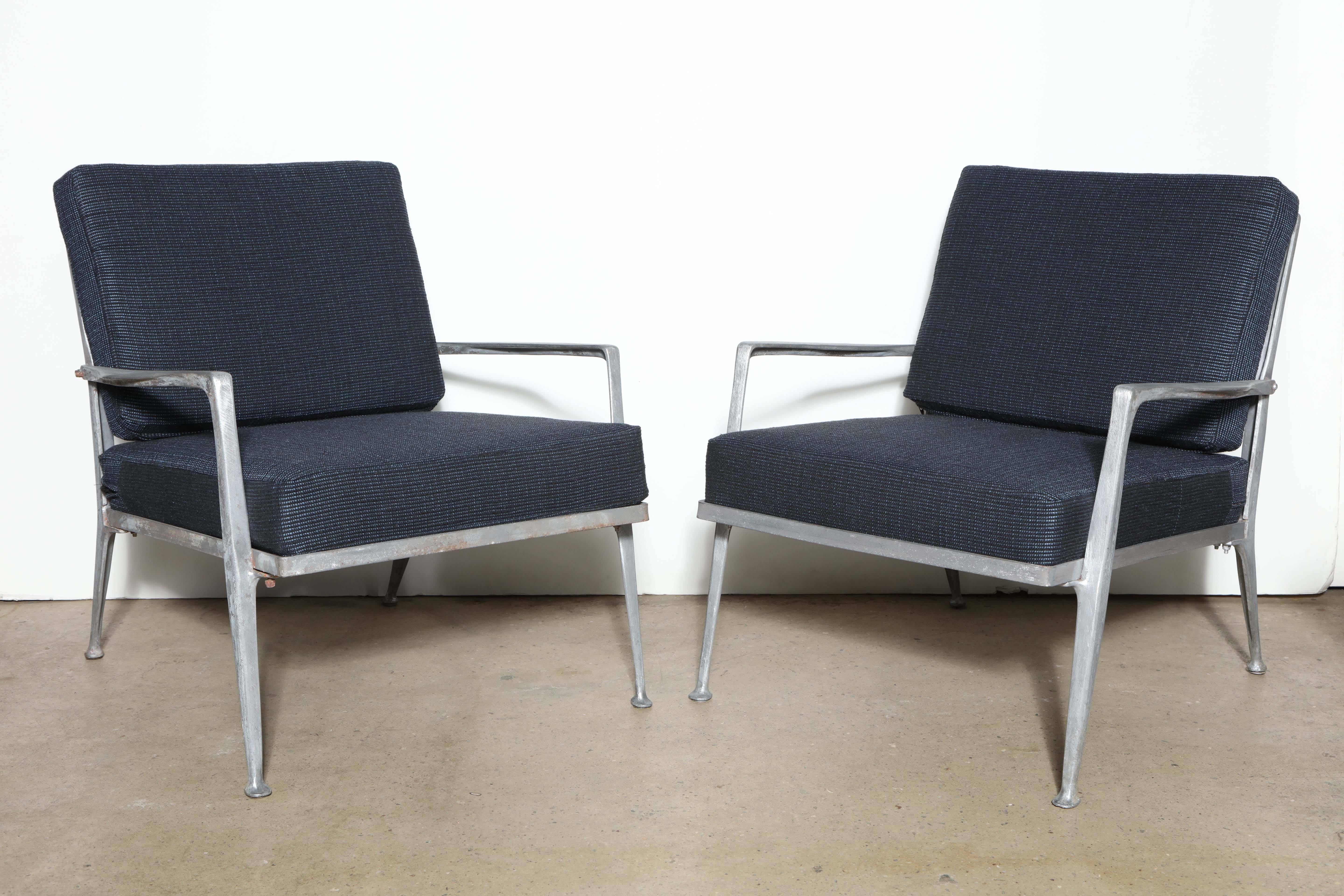Pair of sculptural American Mid Century Molla Furniture Solid Cast Aluminum Lounge Chairs.  Featuring a solid Cast Aluminum framework, cross frame rear construction and four lightweight cushions, newly upholstered in a Dark Blue and Black woven