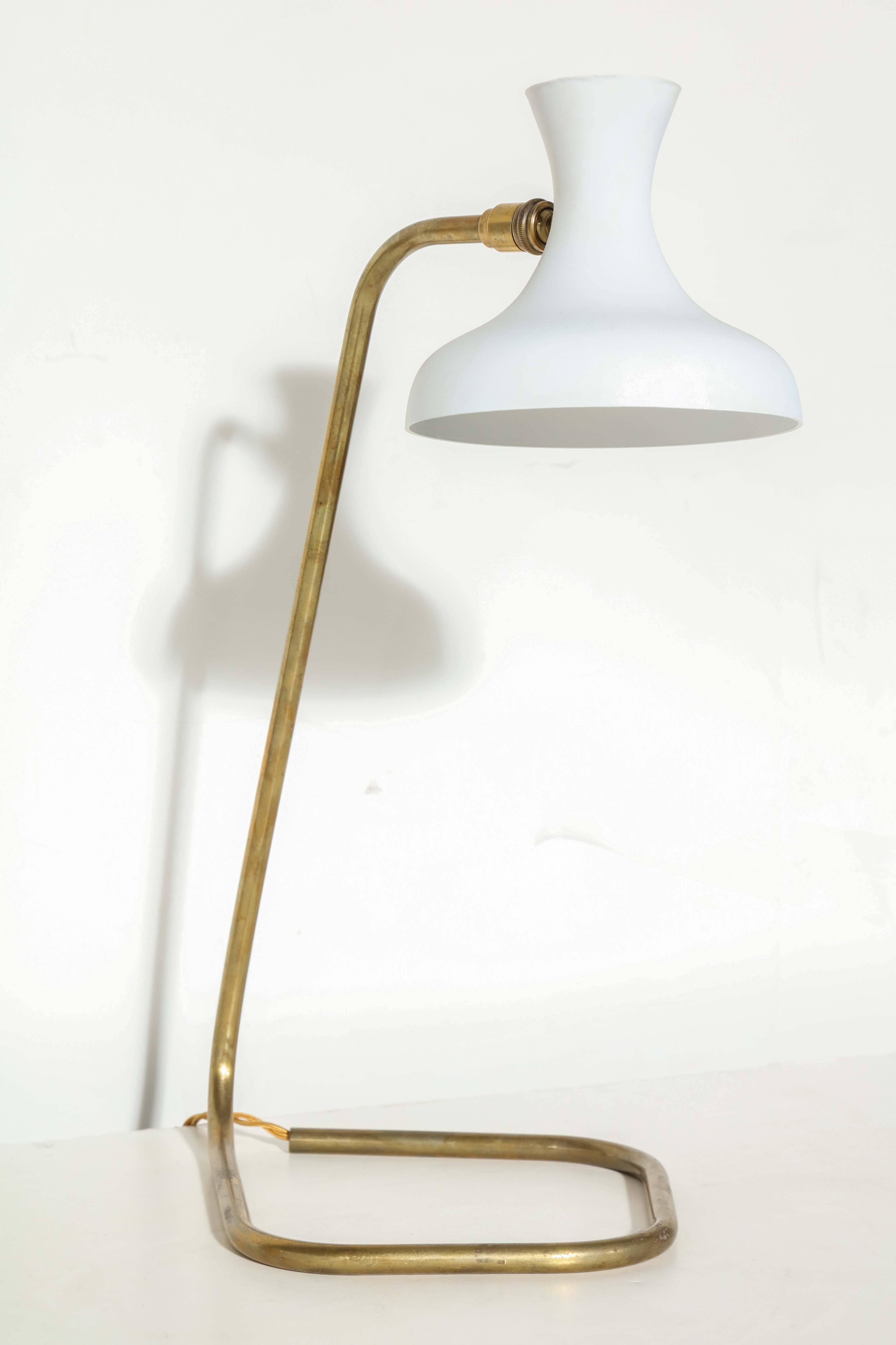 French modern table lamp from the 1950s. Featuring an open tubular patinated brass stem and base with adjustable bell shaped white enameled shade. Measures: 5.5