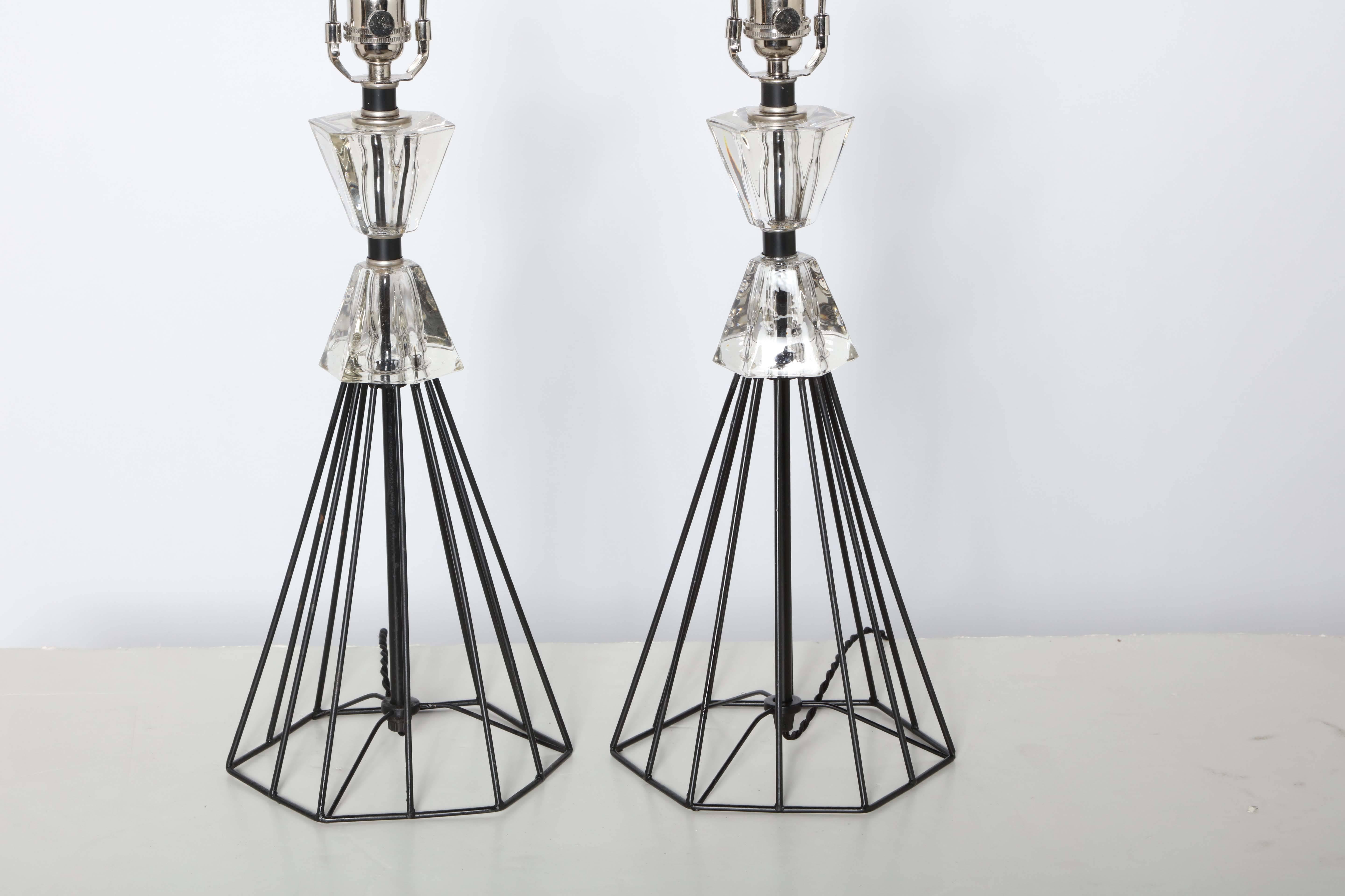 Pair of 1950s Hollywood Regency black wire and crystal table lamps. Featuring a black wire hexagonal base, triangular form framework and
two-piece, triangular, hourglass crystal detail. Great as boudoir lamps,
vanity lamps, bedside lamps or