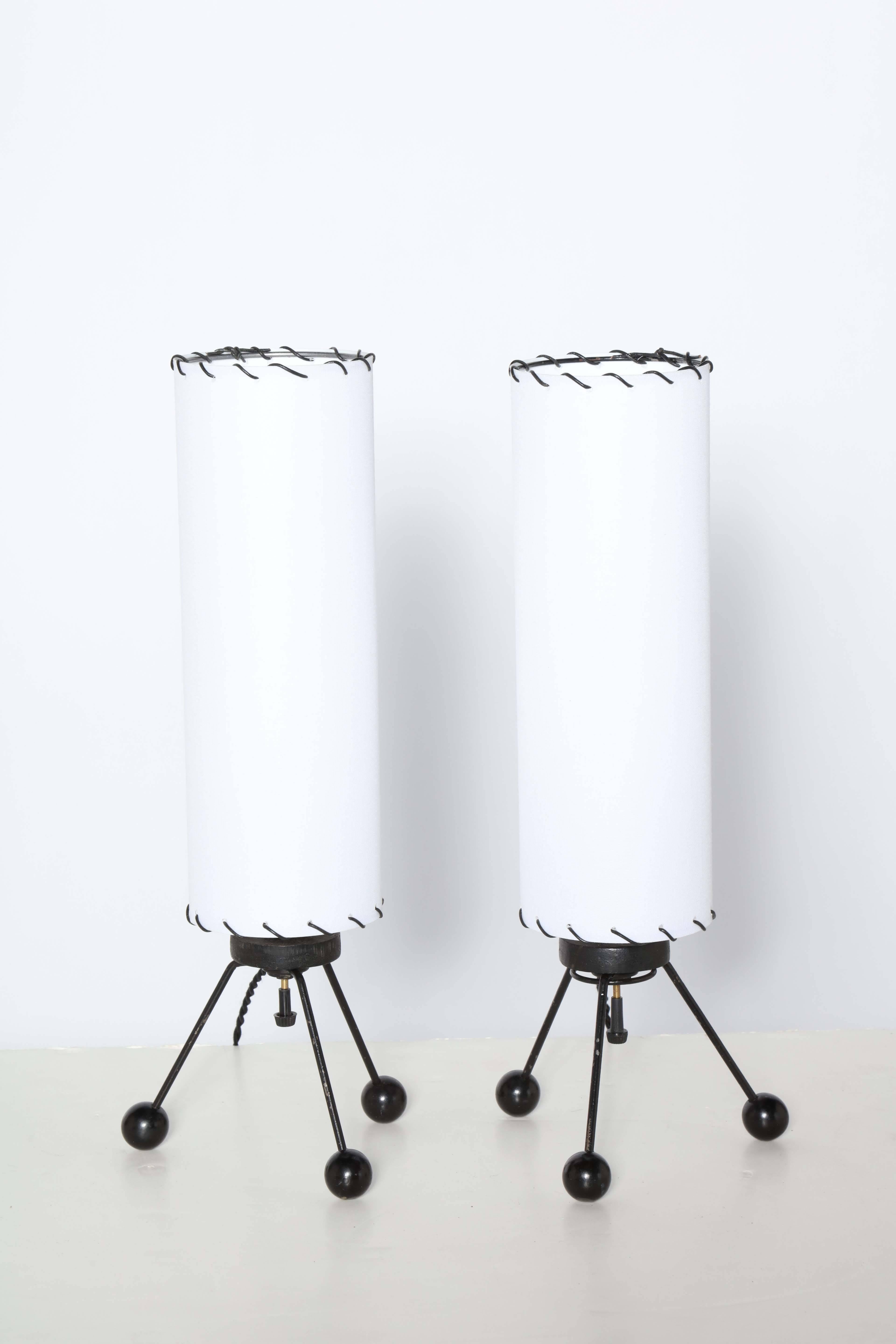 Kleinere American Atomic Black Wire Tripod Lamps mit weißen Leinenschirmen von The Verplex Company, um 1950. Mit dreibeinigen schwarzen Drahtbeinen, runden schwarzen Holzkugelfüßen und schlanken, zylindrischen, neu bezogenen weißen Leinenschirmen