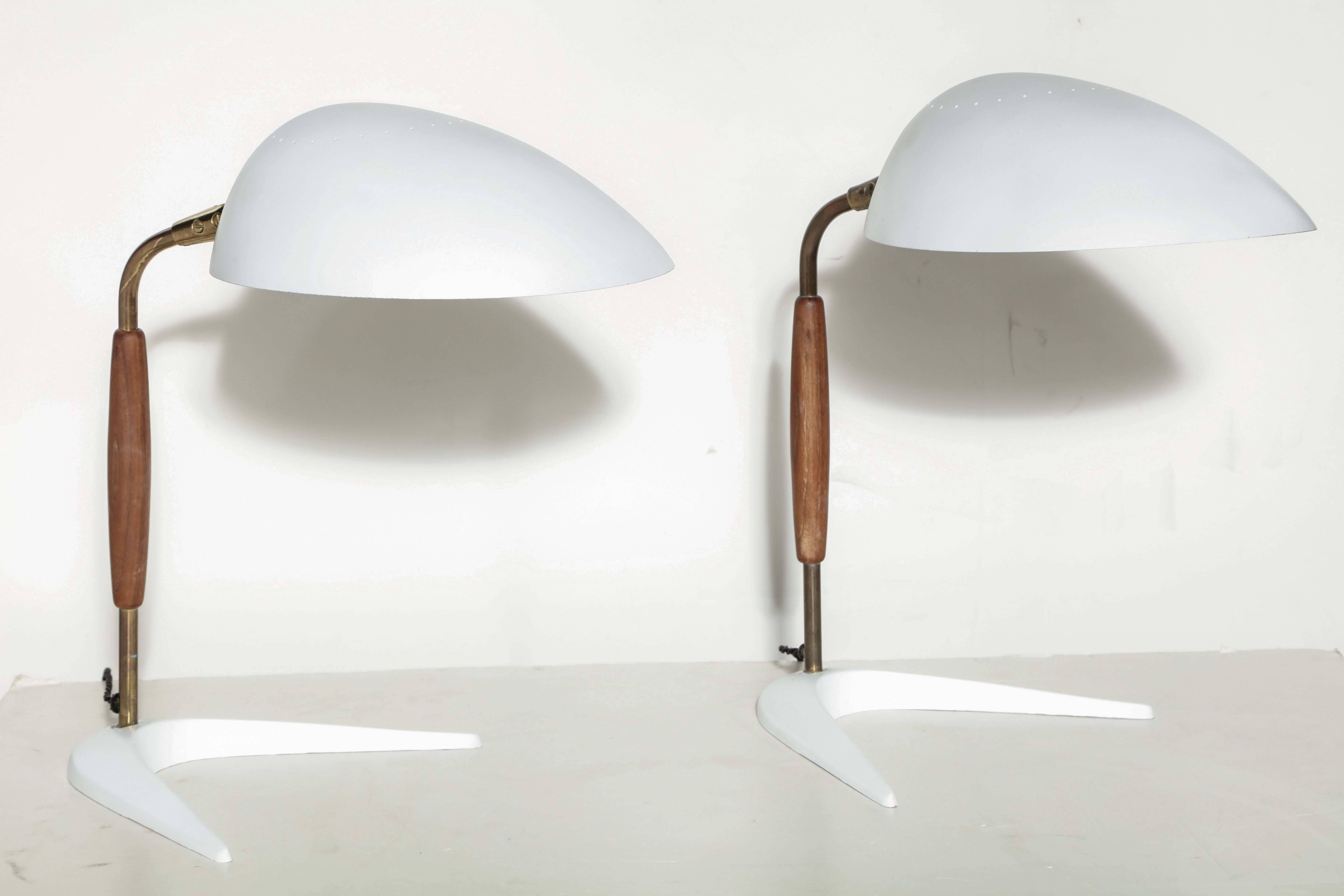 American Mid-Century Modern Gerald Thurston Articulating Boomerang Desk Lamps. Featuring a Teak handle, patinated Brass stem, adjustable and perforated White enameled metal hood Shade and heavy boomerang metal base. Without diffuser. Two Lamps