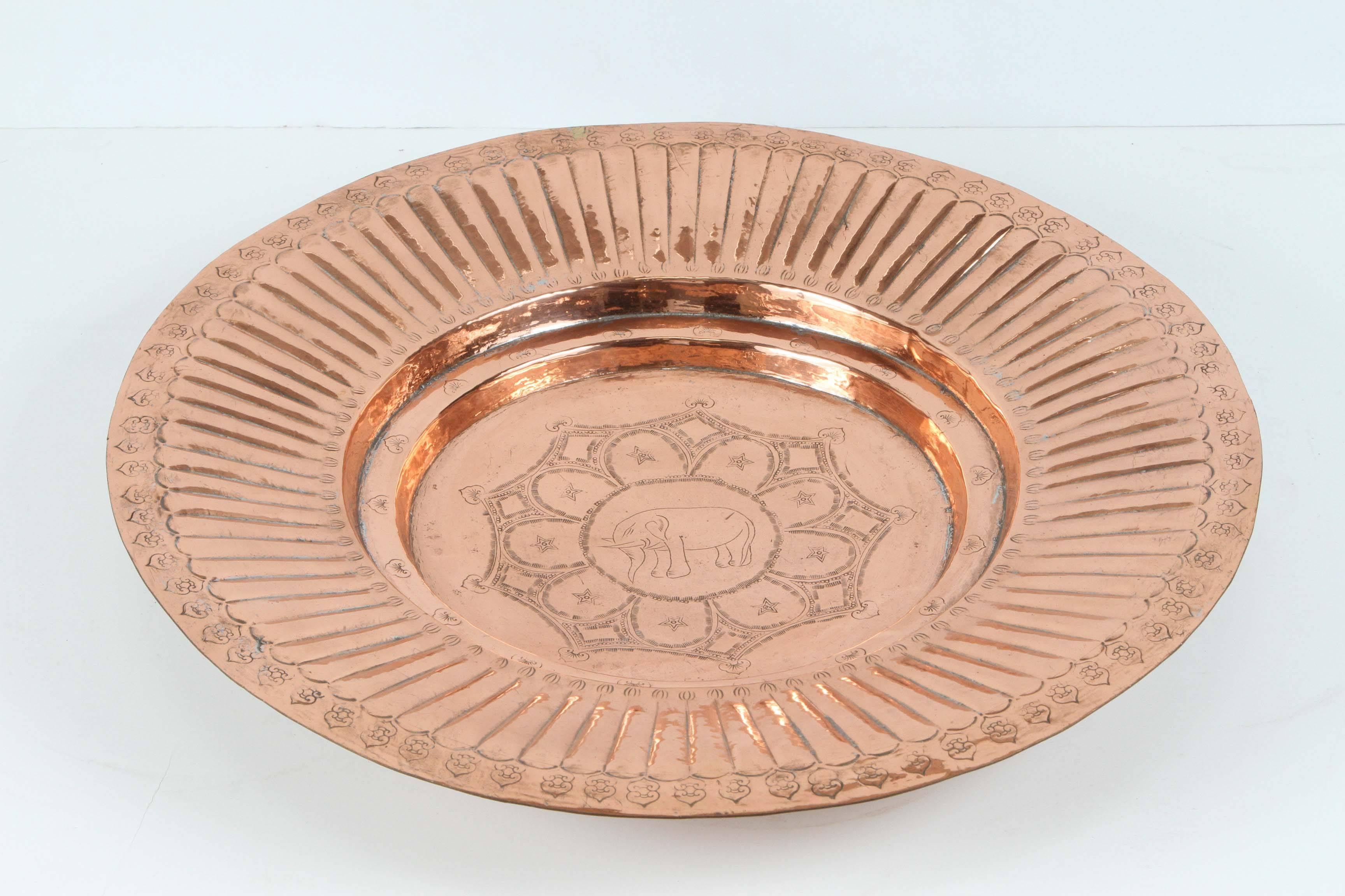 Polished round Asian Rajasthani metal copper tray, hand-hammered with geometric design in the middle, and an elephant in the center, the elephant in the Asian culture means protection and long life.
Handcrafted in India, Rajasthan.
Great to use as a