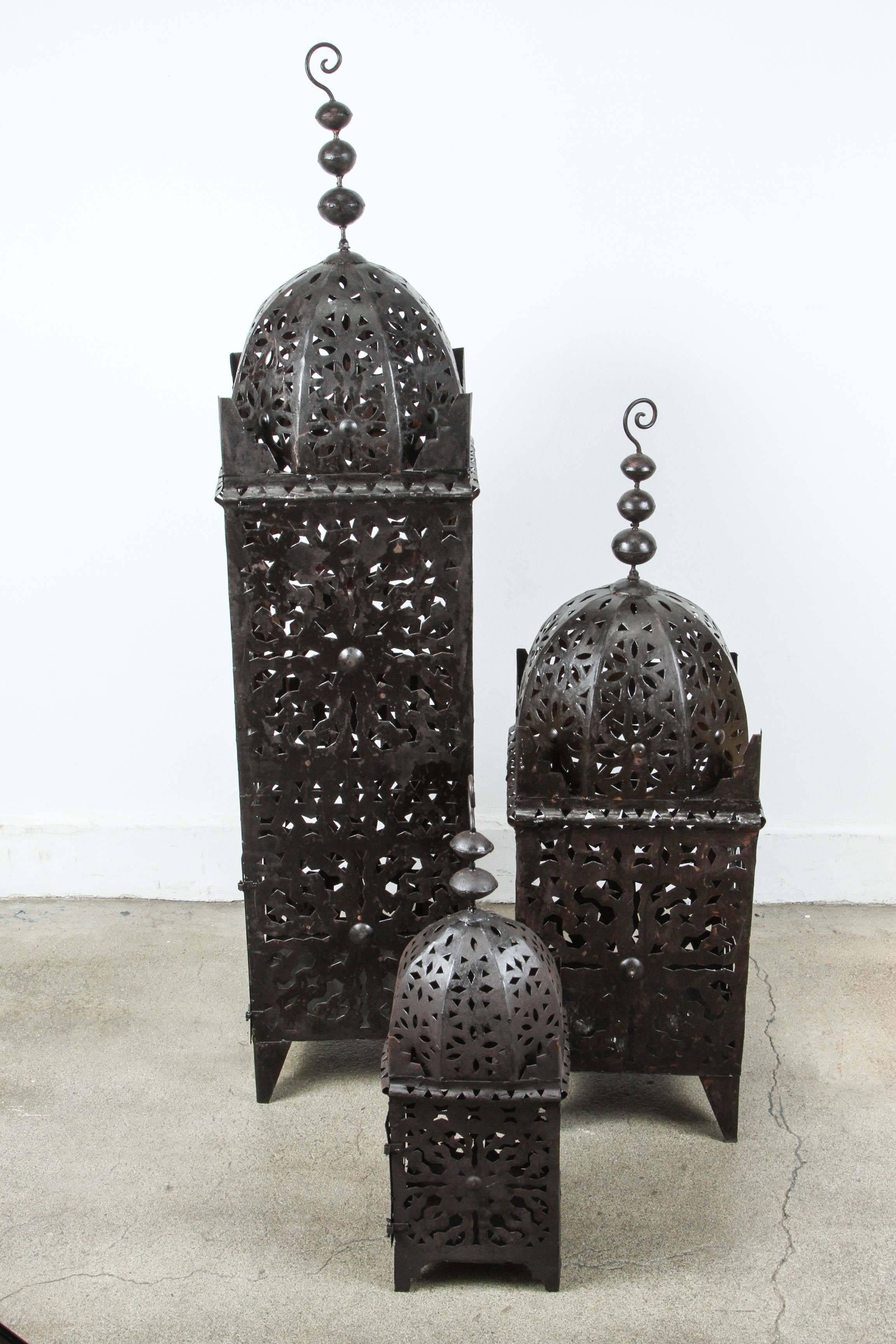 Set of three Large Moroccan metal candle lanterns.
Hurricane candle lamp handcrafted in Morocco by artisans, metal hand-cut and hammered, opening in front for use with pillar candles.
The lanterns are great to use indoor or outdoor. Multiple