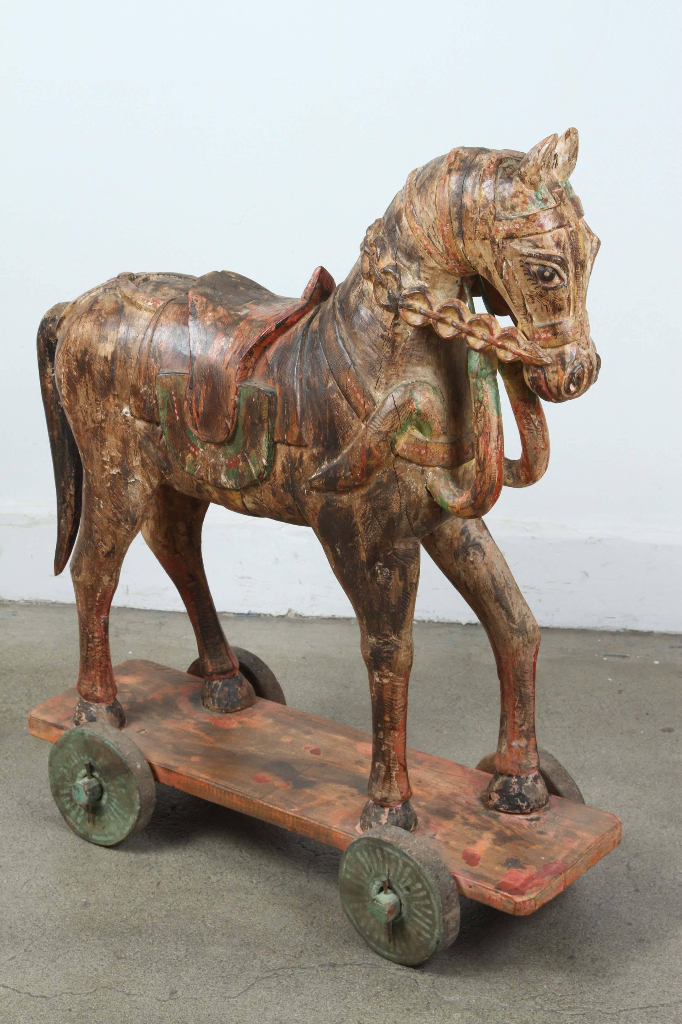 Pair of 19th century hand-carved oversized wooden Indian temple horses with poly-chrome decorated sitting a top of a wheeled board. 
Large heavy Antique Southeast Asian Carved Polychrome Wood Horses.
Antique Southeast Asian carved wood model of a