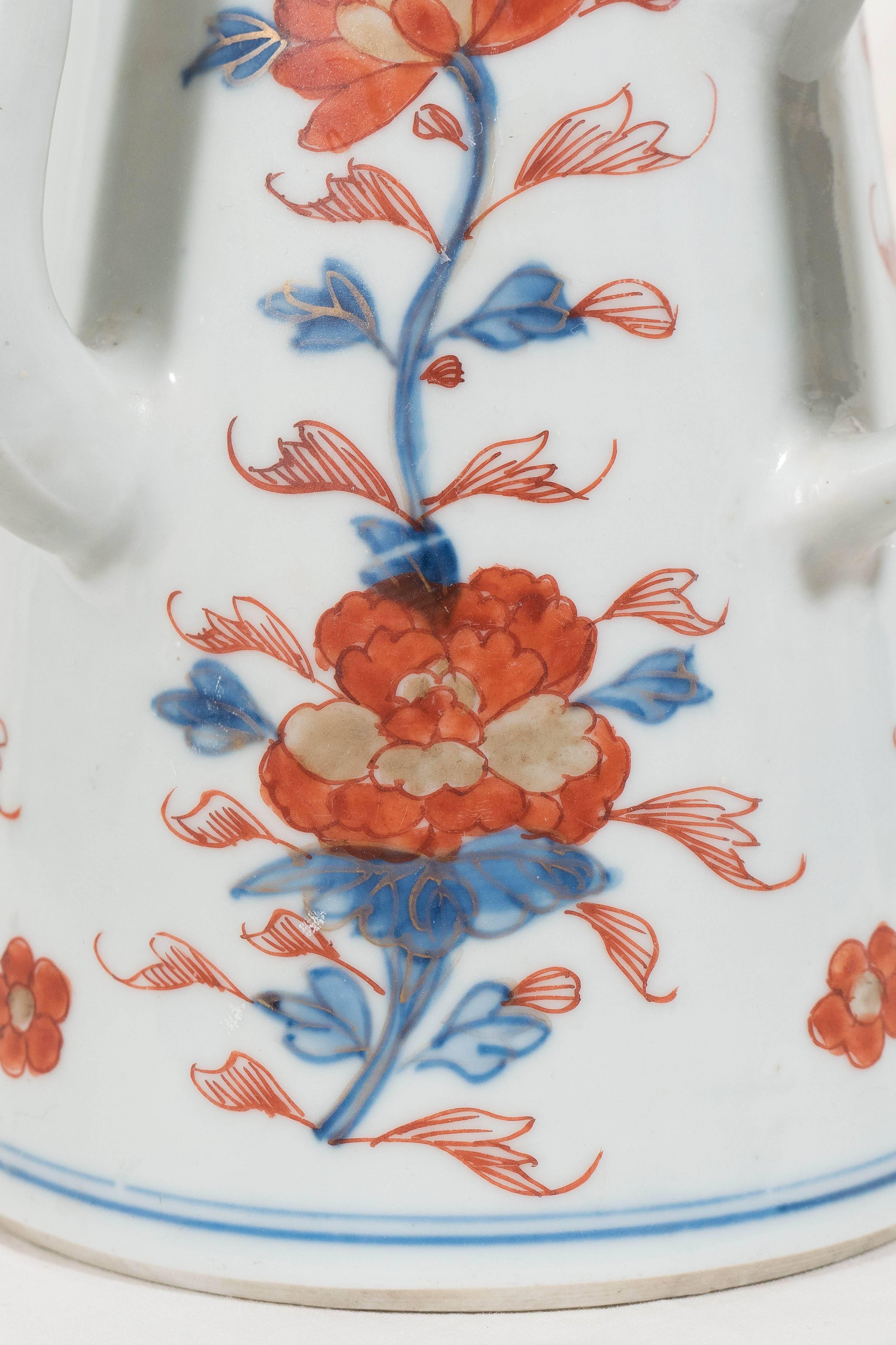 A large Chinese coffee pot of lighthouse conical form with a domed cover and a lotus finial. Decorated in rich Imari colors of underglaze iron red, cobalt blue and gilt. The combination of the contrasting colors of red and blue is especially strong.
