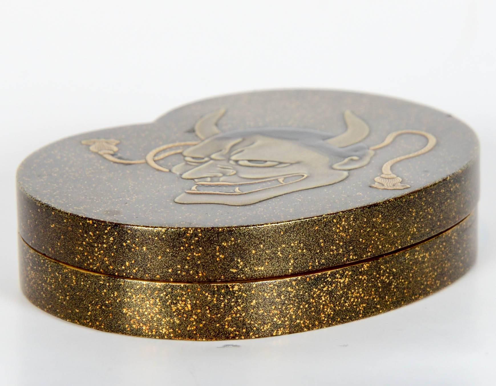 Small kidney shaped lacquer nashiji kobako. The lid features the no mask of Noh theater character representing the Hannya demon in polychrome lacquer.
The interior is in nashi-ji gold lacquer.

Japan - Meiji (1868-1912).

Height 1.5 cm - length