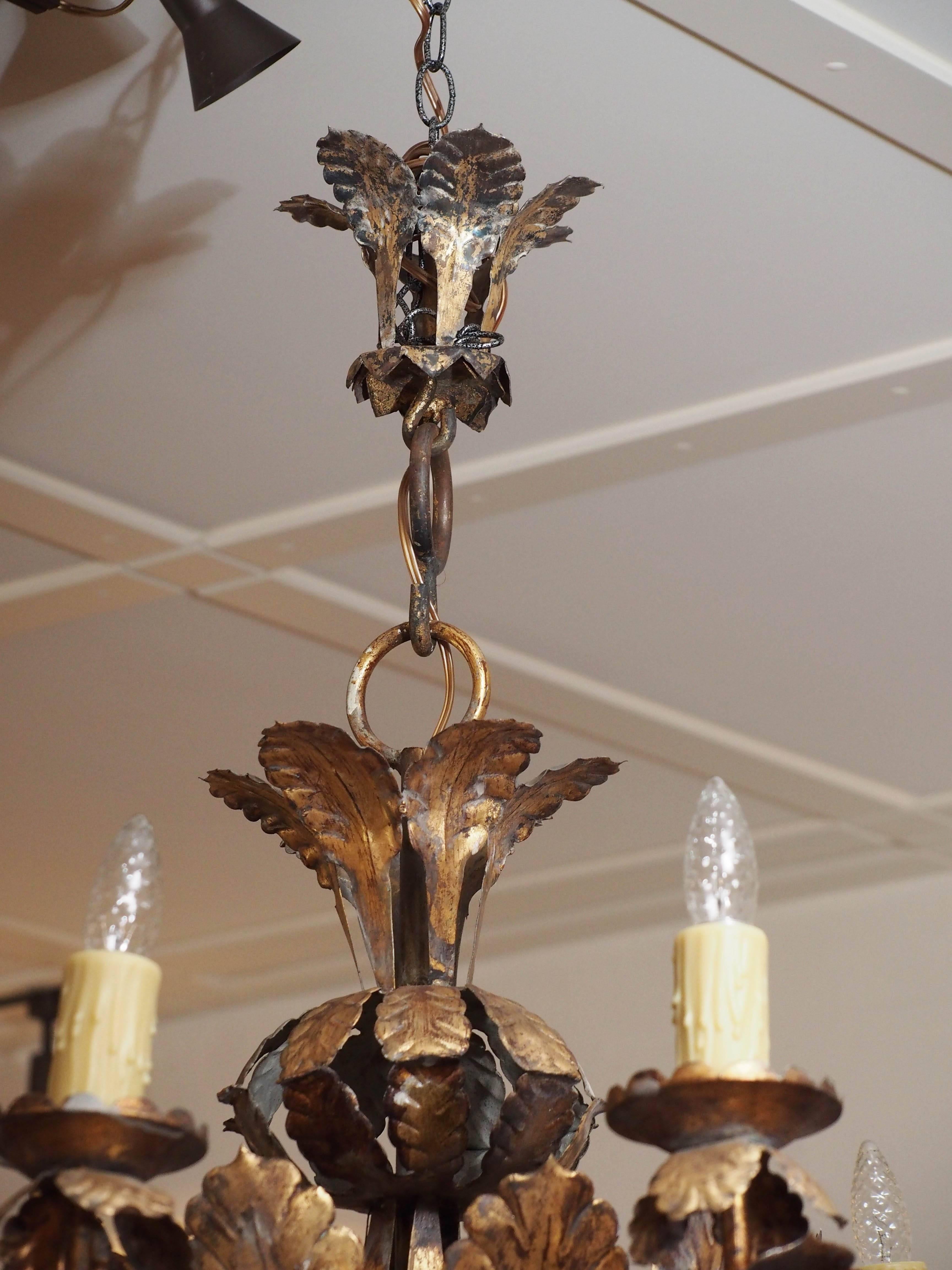 Early 20th century Italian tole nine-arm chandelier with worn gold leafing and wax sleeves. This fixture has been recently re-wired by Wirthmore Antiques, circa 1920.