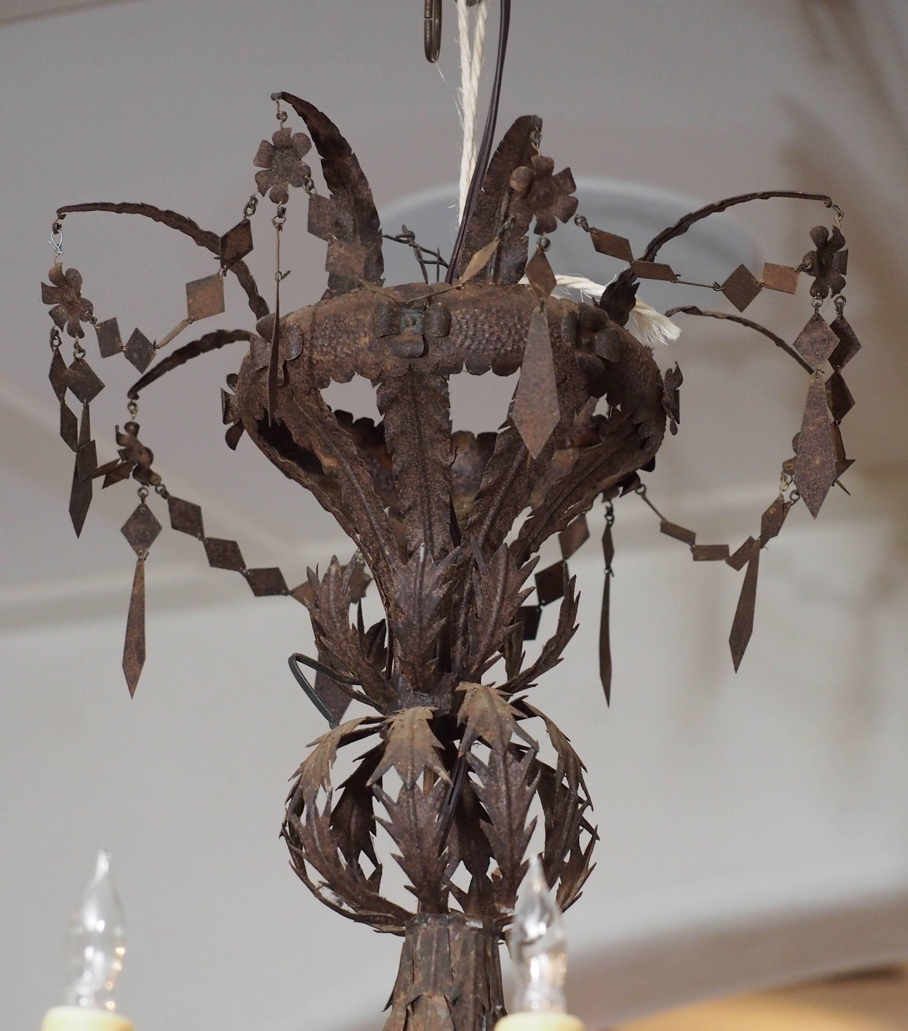 Early rare and unique Spanish Louis XVI style eight-arm iron chandelier with hand-cut medallions and wax sleeves from a small chapel in Spain. This fixture has been recently re-wired for American current, circa 1810.