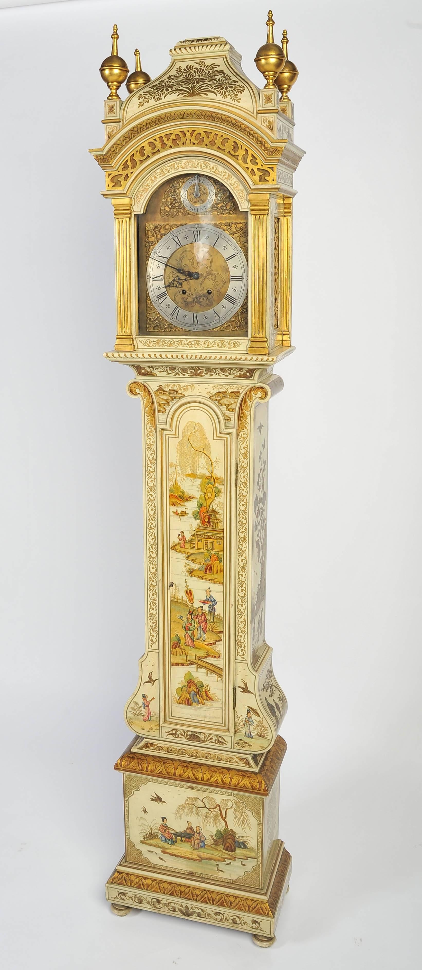 A very good quality Chippendale influenced chinoiserie ivory lacquer grandmother clock. Having gilded decoration to the finials and case, classical oriental scenes, brass faced arch dial and an eight day movement.