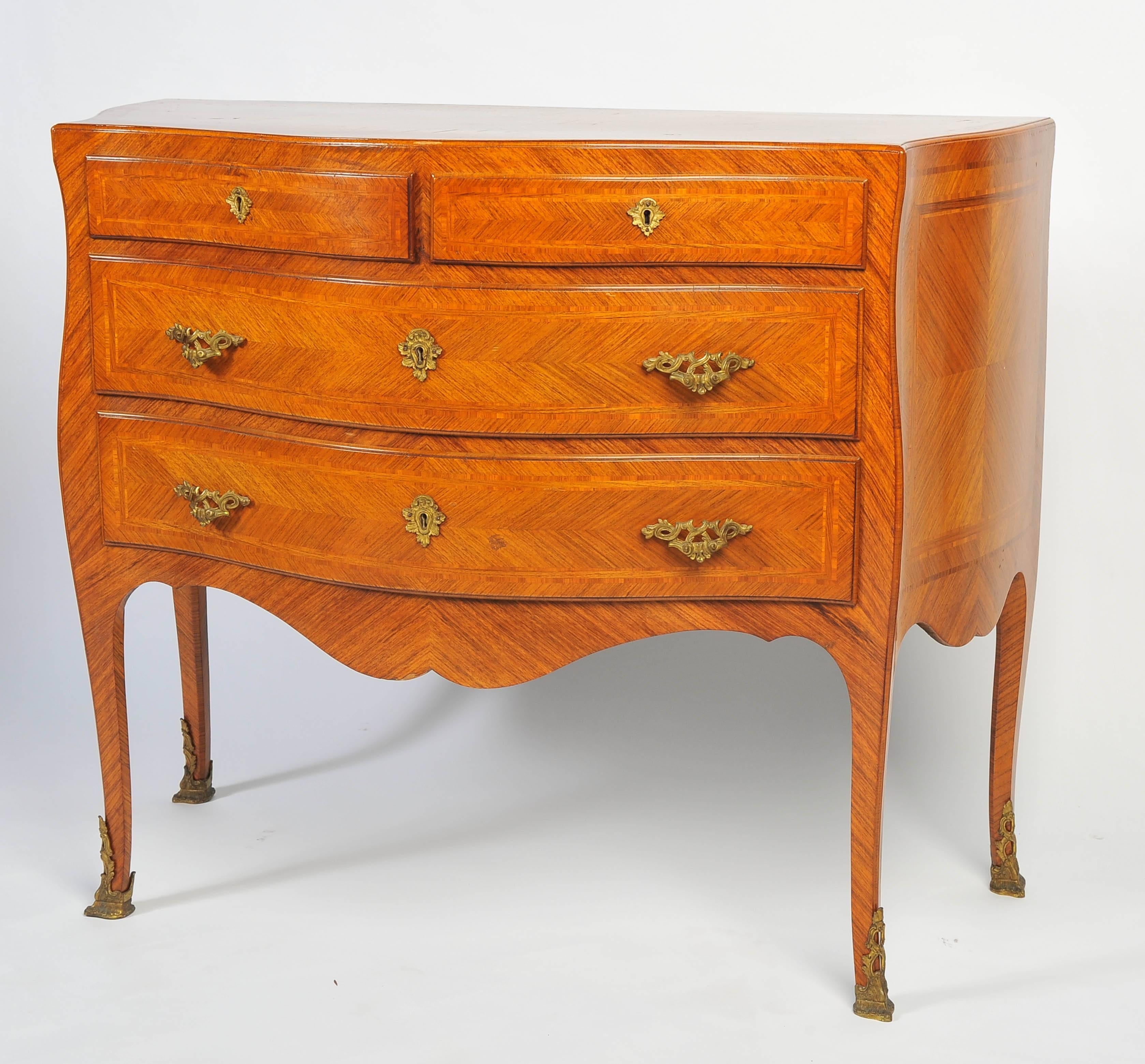 A good quality pair of French Louis XV style kingwood veneered serpentine fronted commodes, the top having crossbanding and quartered veneers, two short and two long drawers each with crossbanding and quartered veneers to match. Beneath the drawers