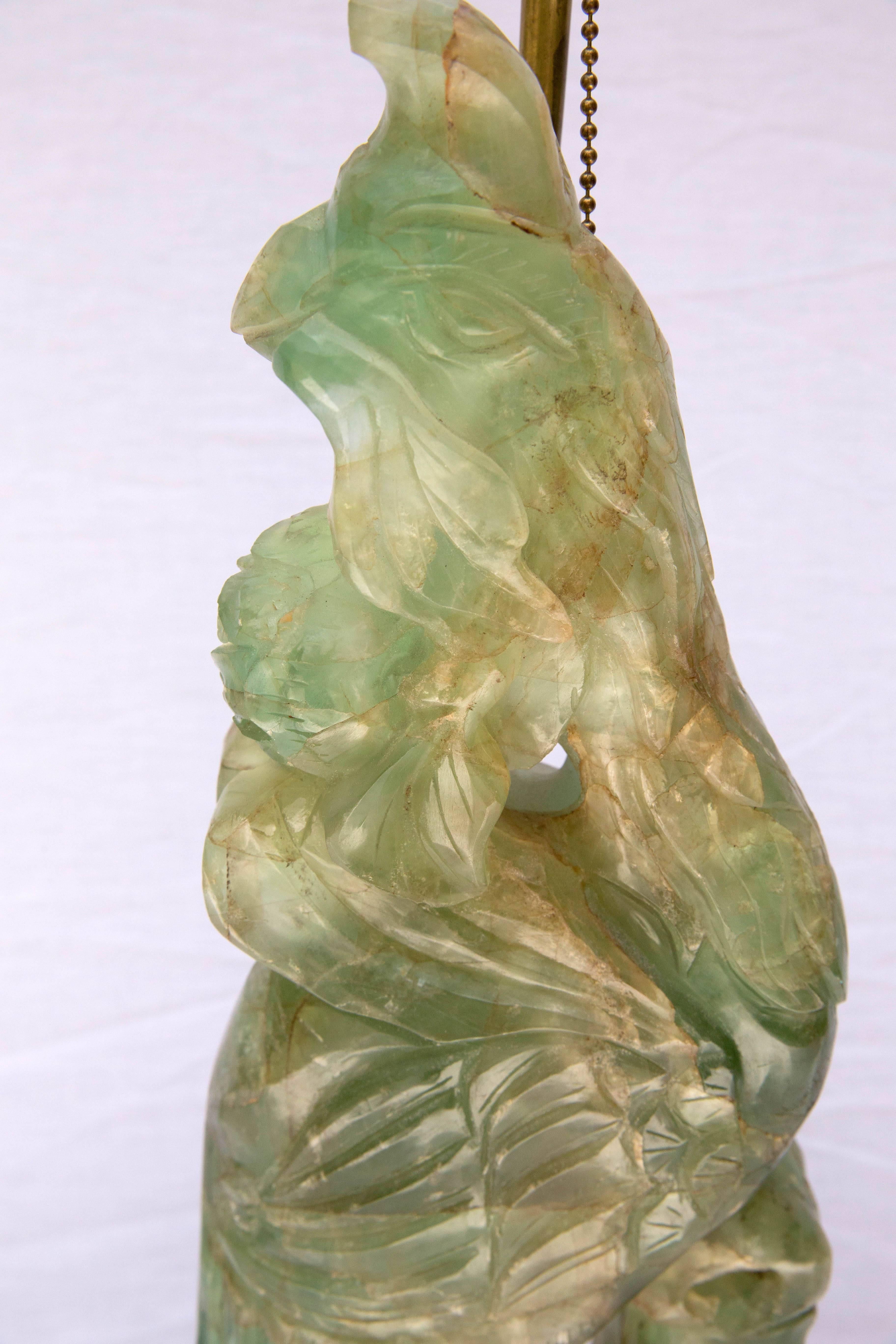 Geschnitzte Jadeskulptur eines Phönixes auf einem Holzständer, der als Lampe dient.