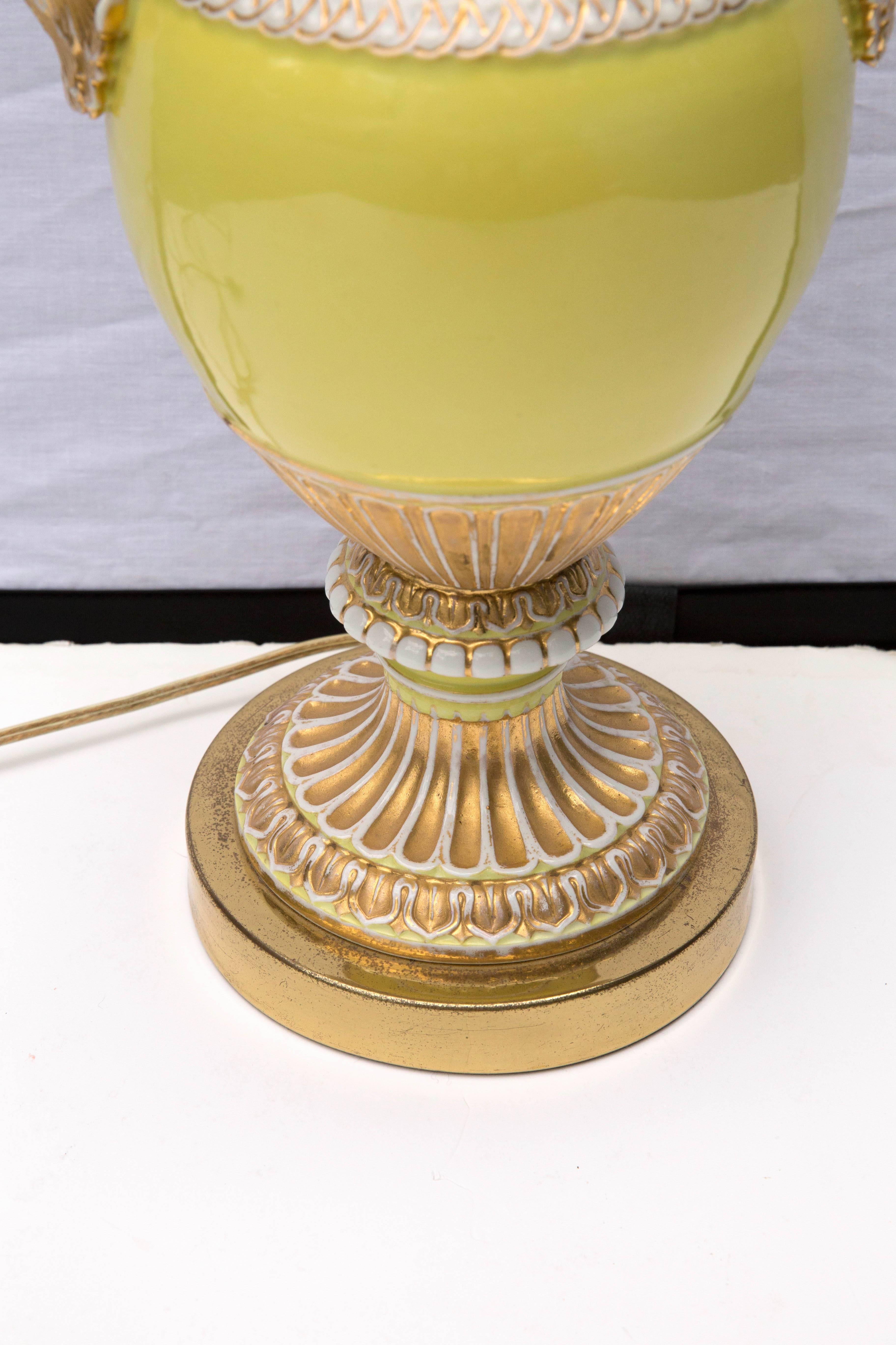 This 19th century vase have a beautiful yellow color with gilt gold highlights and curled white snakes as handles. To become a table lamp the vase has been capped and set on a base.