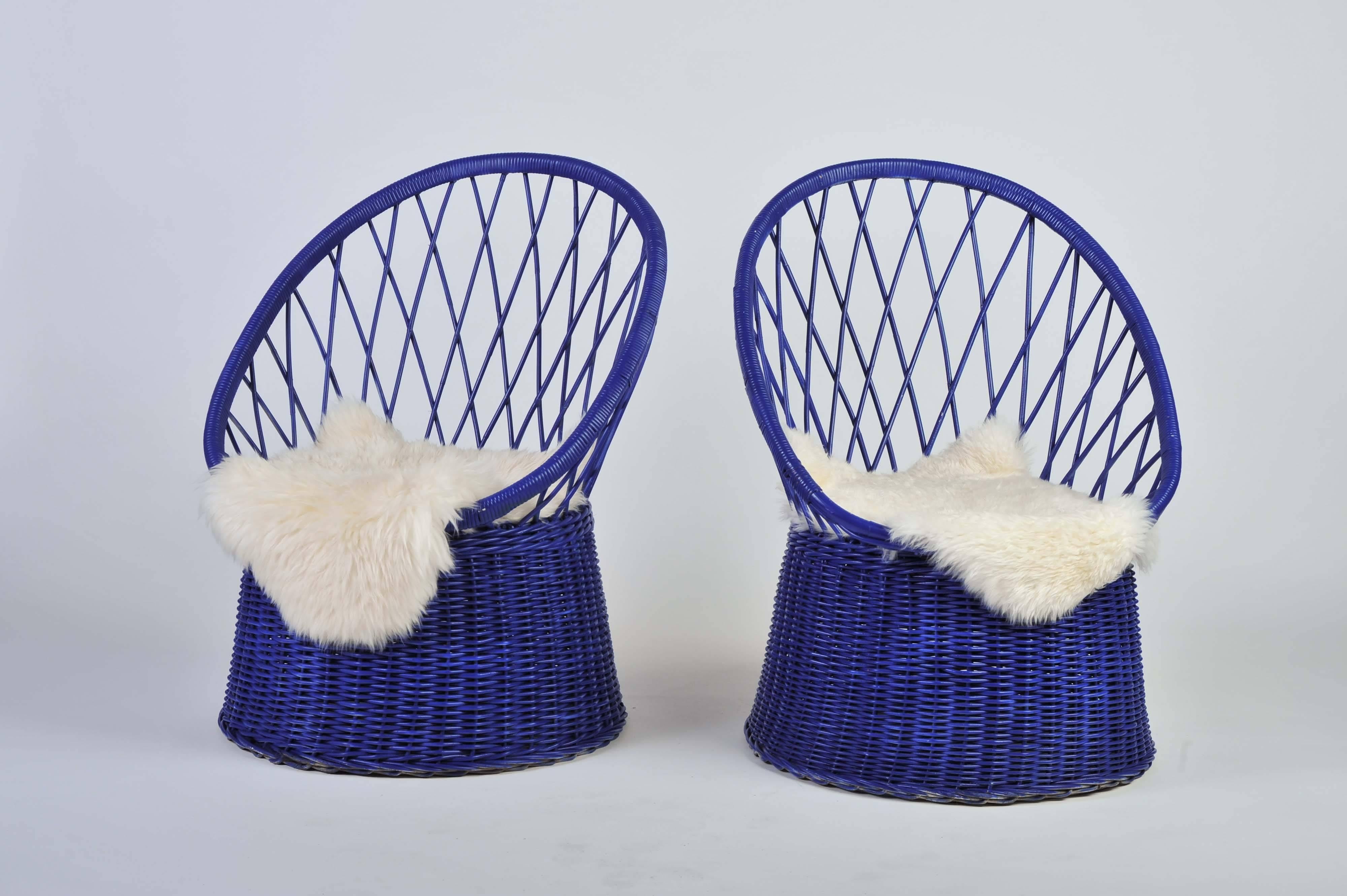 A beautiful vintage 1950s pair of chairs. It is a good quality rattan in deep royal blue club chairs. 

Maker unknown.