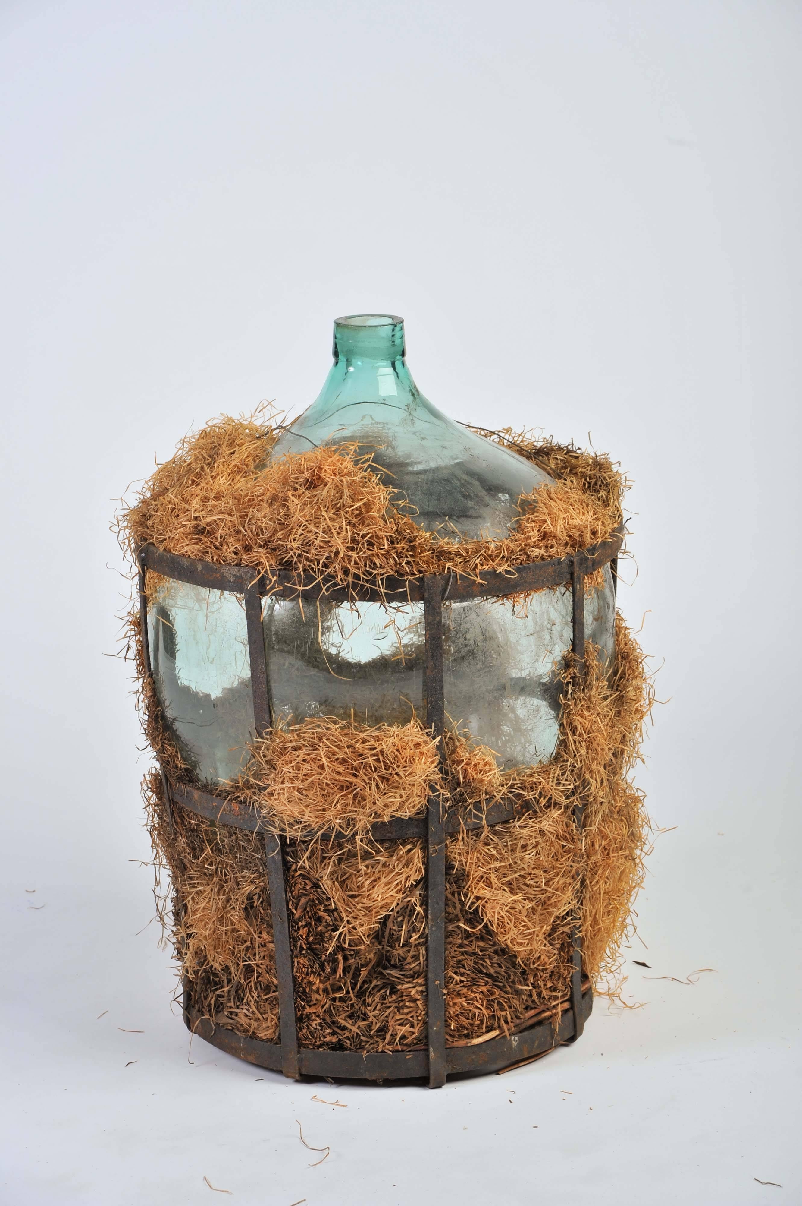 This wonderful example of an early 19th-century demijohn. Combined with hay and the original metal storage crate.