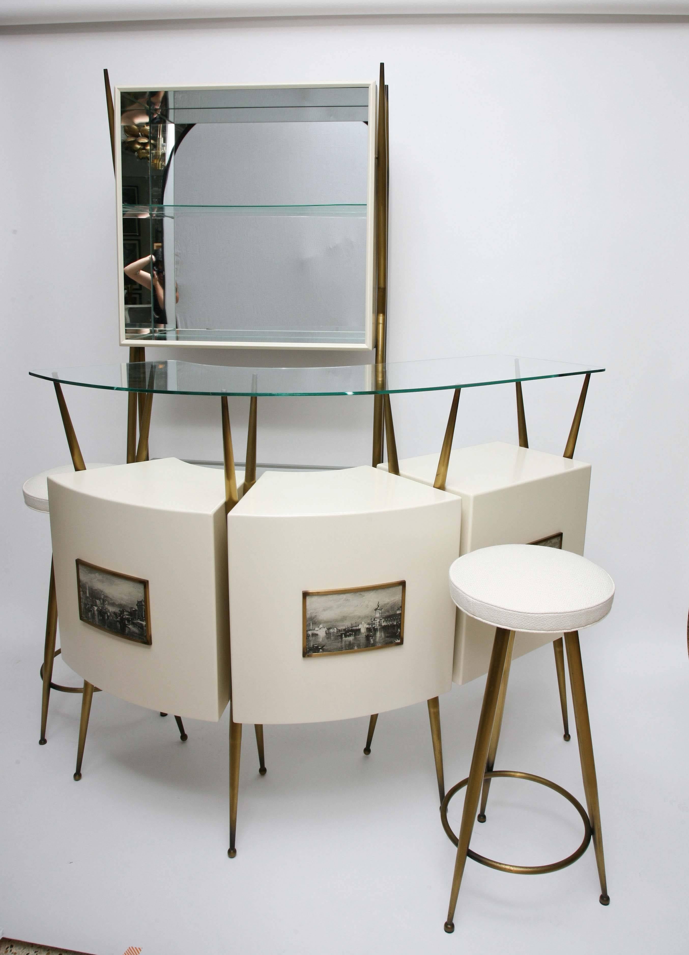 Que bella! 1950s Italian bar suite in the manner of Gio Ponti. The suite includes a glass-topped bar, a mirror-backed standing wall unit, and two matching bar stools, all with patinated brass legs and hardware. Venetian harbor scenes, styled after