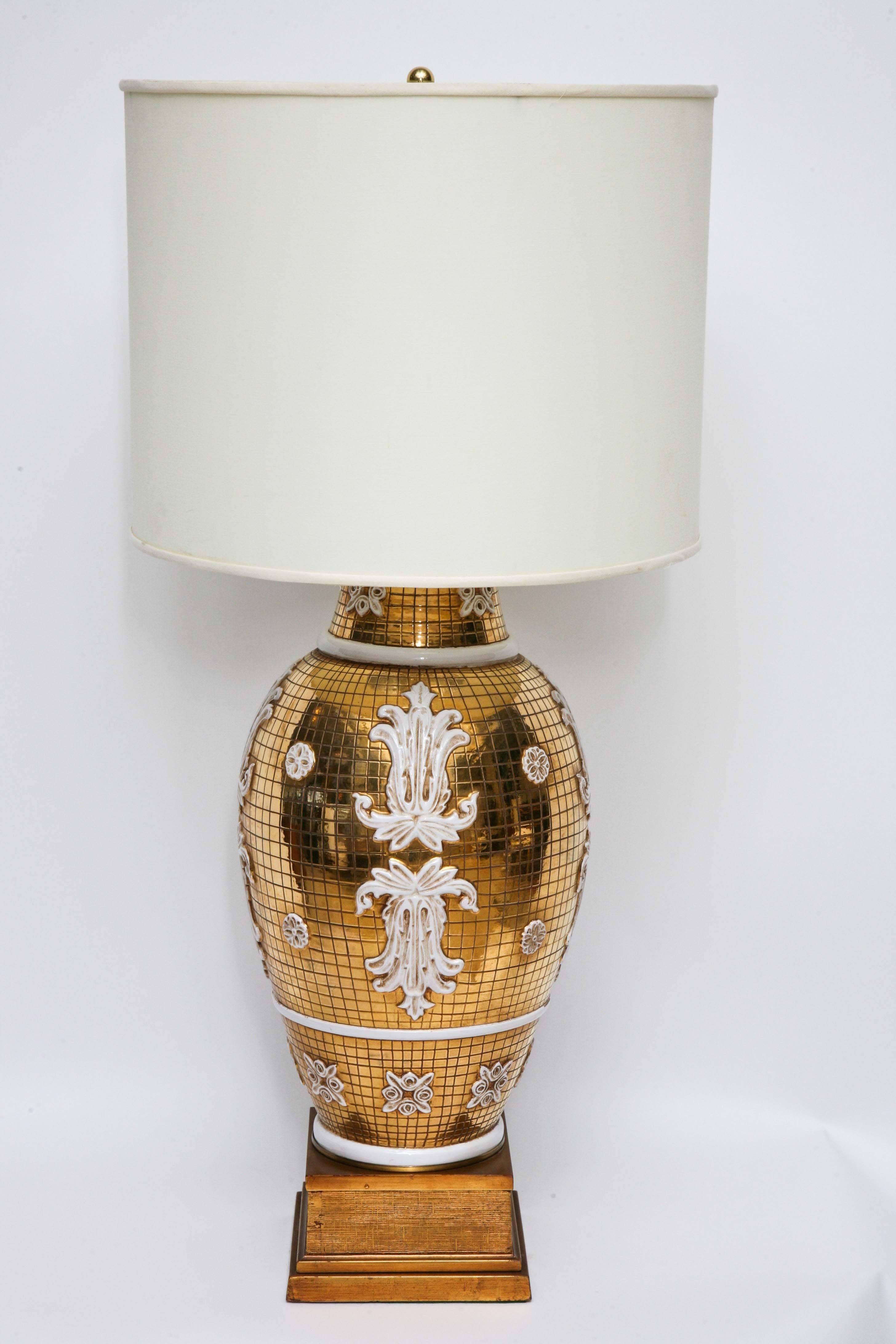 Designed and manufactured by Ugo Zaccagnini for Marbro, this monumental pair of lamps is equal parts Italian baroque and disco fever. Handcrafted Italian ceramic with metallic gold, scored body and white-glazed appliques. Giltwood bases with brass