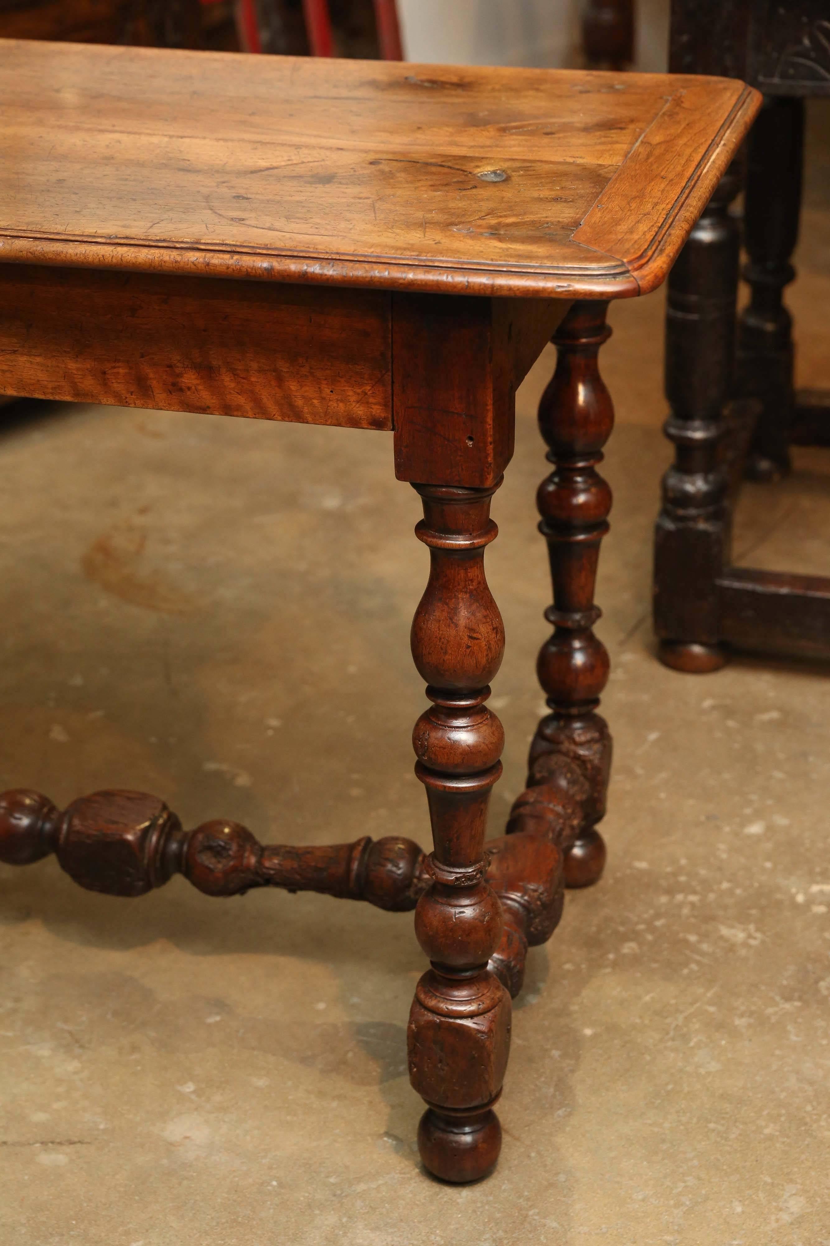 18th century Louis XIII walnut table from France with beautifully carved H stretcher and carved legs. There is a single drawer along one of the longer sides. Wonderful patina.