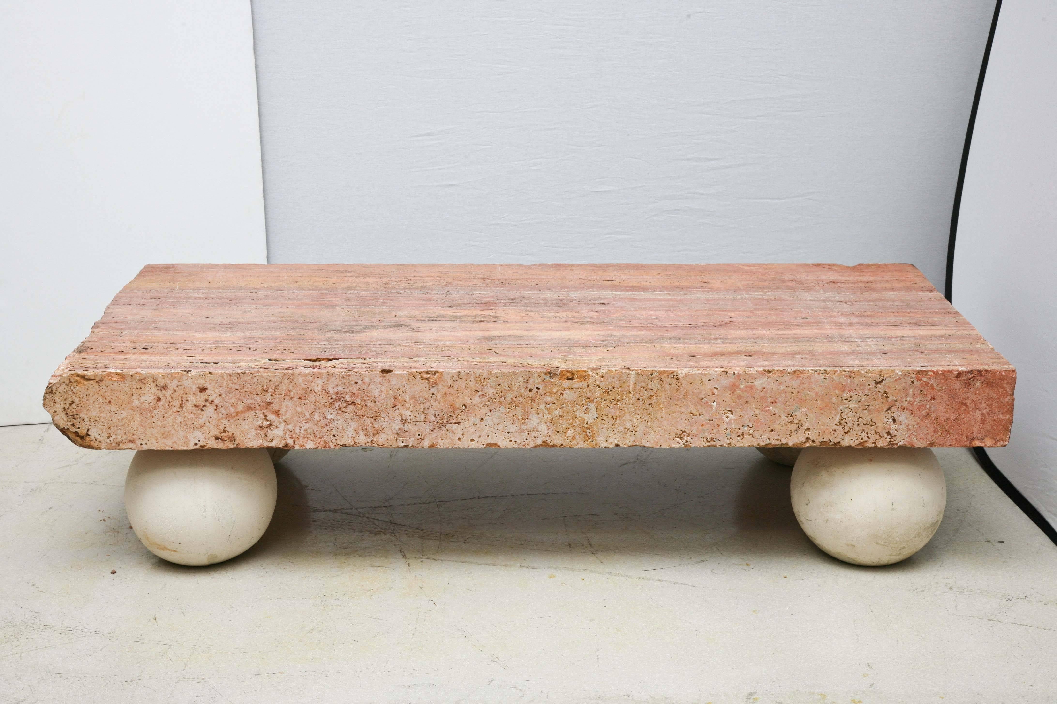 Massive slab coffee table made of rouge royal marble with four stone ball feet which may be arranged in a variety of positions as they are not glued or drilled to slab.