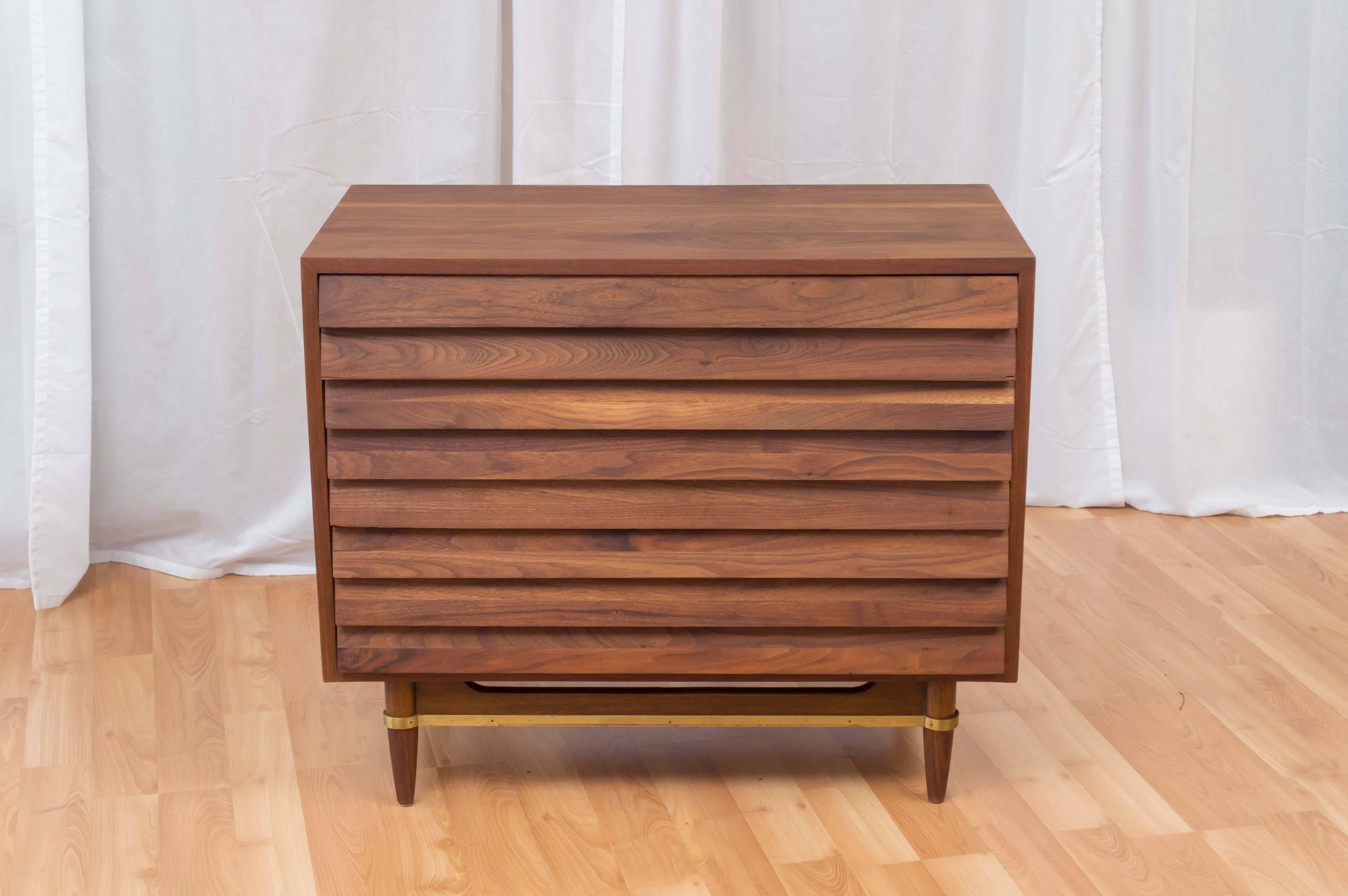 A three-drawer walnut dresser from designer Merton Gershun’s “Dania Collection” for American of Martinsville.

Clean lines and Classic louver-style design constructed out of beautifully figured chocolate brown walnut. On torpedo feet, with a brass