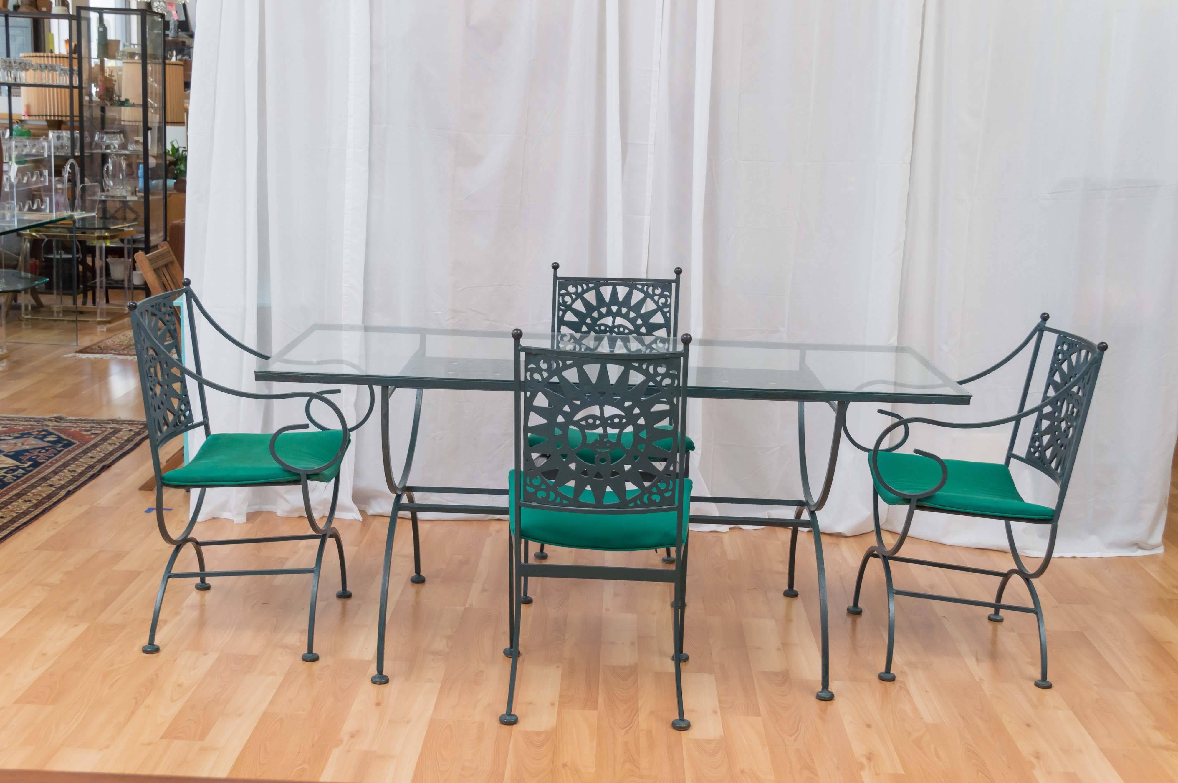 An enameled wrought iron five-piece dining or patio set from Arthur Umanoff’s rare “Mayan Collection” for Shaver-Howard.

This fanciful set includes a glass-topped table, two dining chairs, and two captains chairs. Pieces feature a whimsical