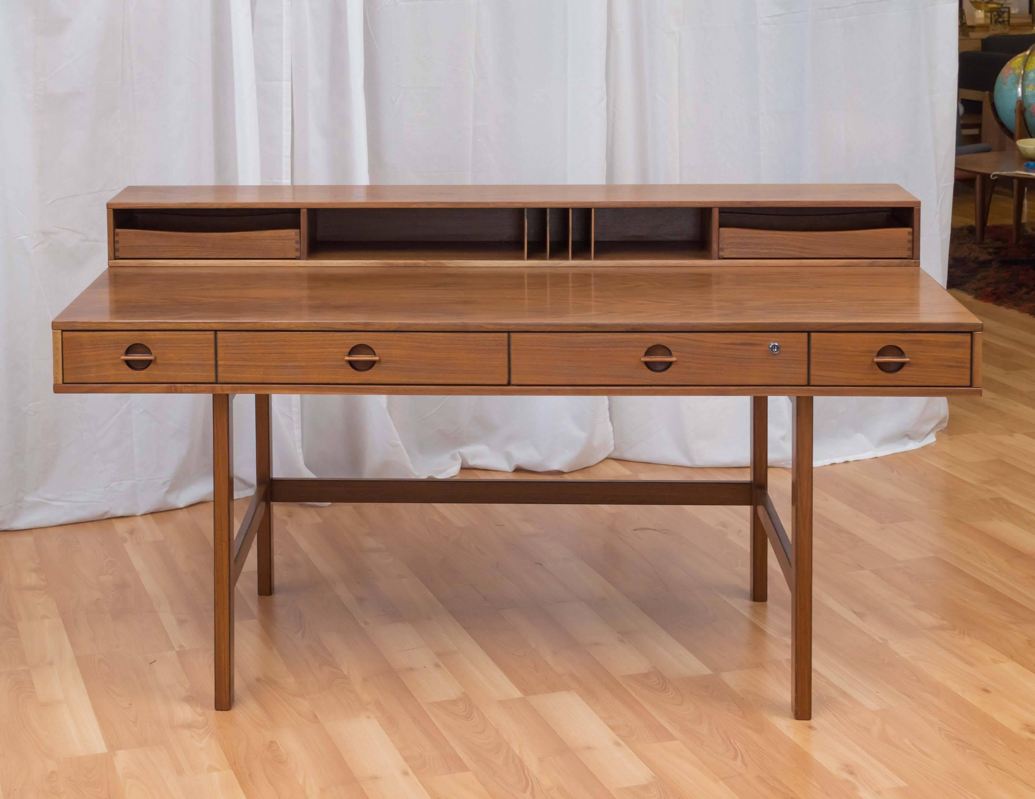 An expansive, expandable, and altogether stunning Danish modern walnut desk by Jens Quistgaard for Peter Løvig Nielsen.

Defined by clean architectural lines and elongated rectangular forms, this clever desk can be used with its hinged top section