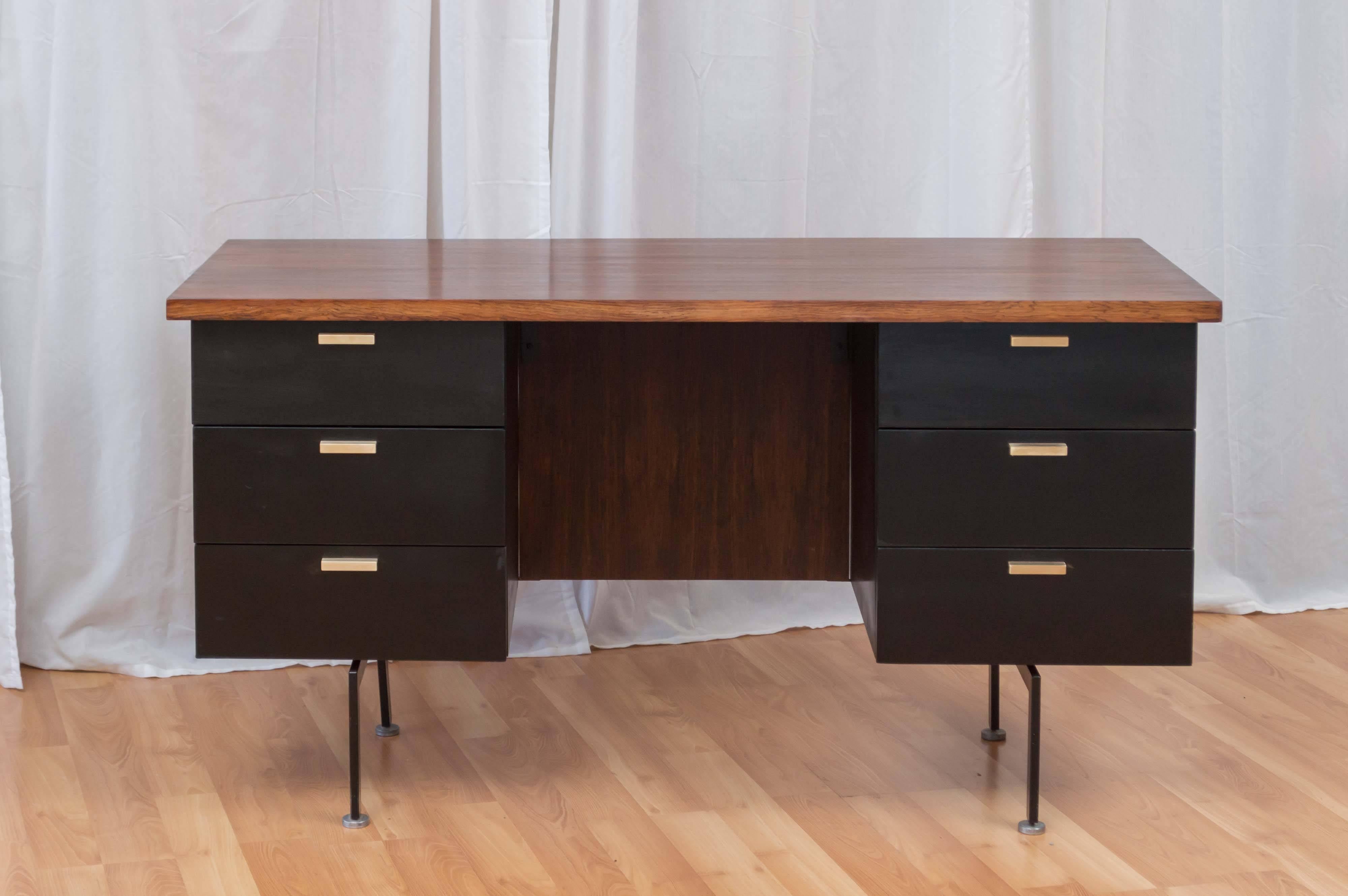 A handsome and rare six-drawer rosewood executive desk by Robert John Furniture in the style of George Nelson.

Thick and expansive top is finished in lively, bookmatched rosewood veneer, as is the modesty panel. Cabinets and drawers are black