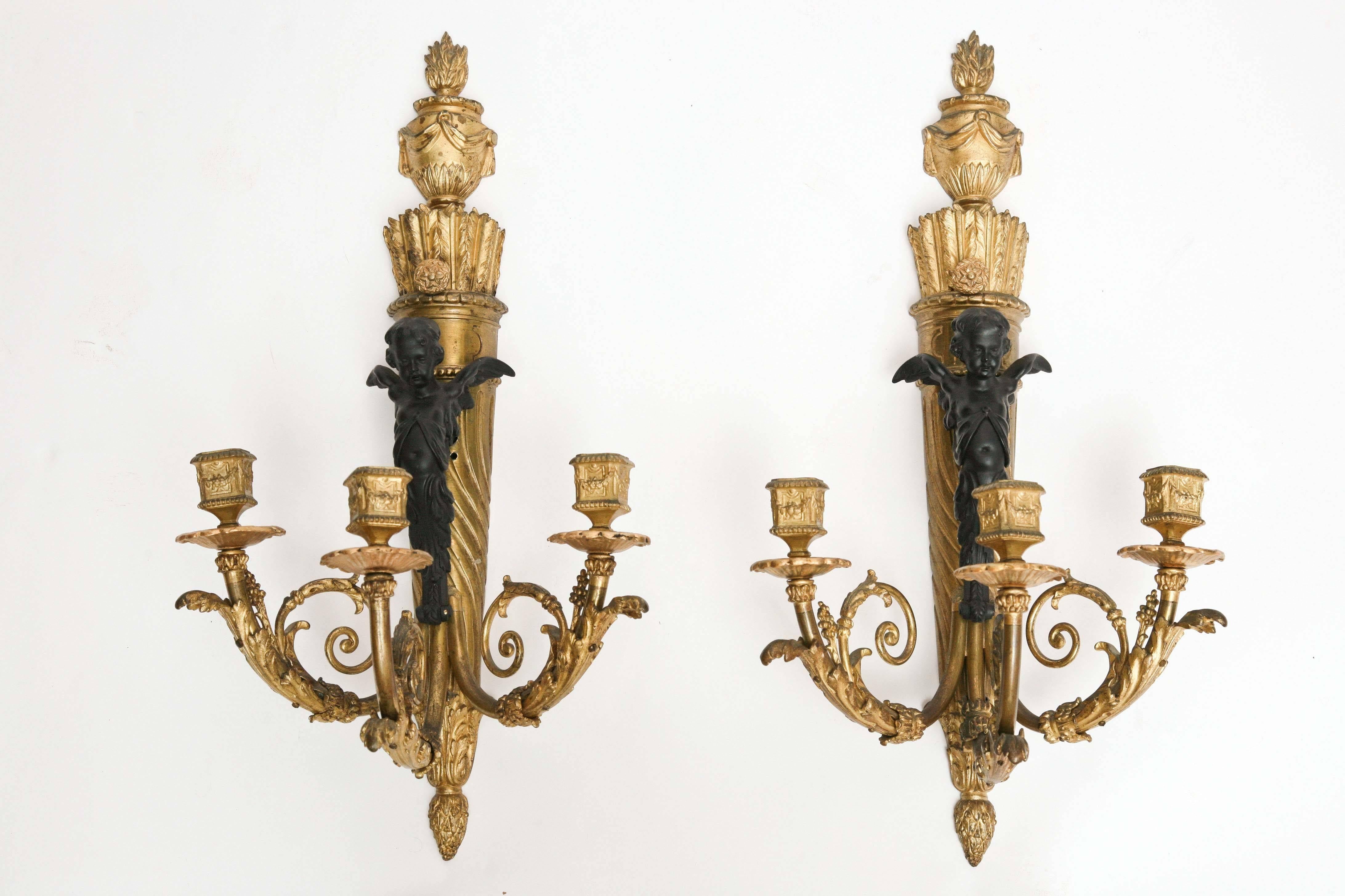 The sconces are fashioned with patinated cherubs.