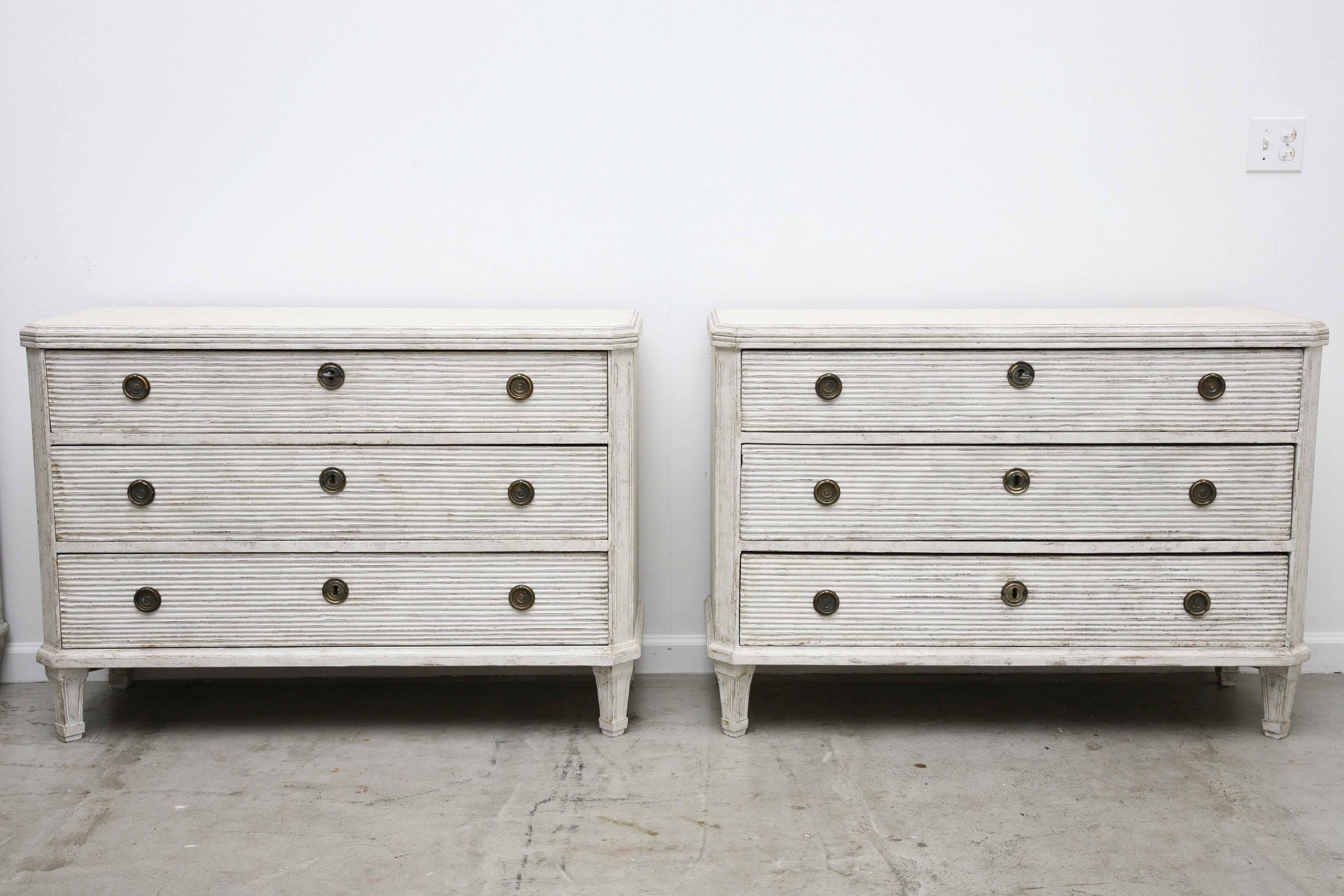 Pair of antique Swedish Gustavian large painted chests, fronts of the drawers
have reeded carved details, cut corners with fluted carving ending to Classic fluted tapered legs, Swedish greyish-white painted finish, interior of some of the
drawers