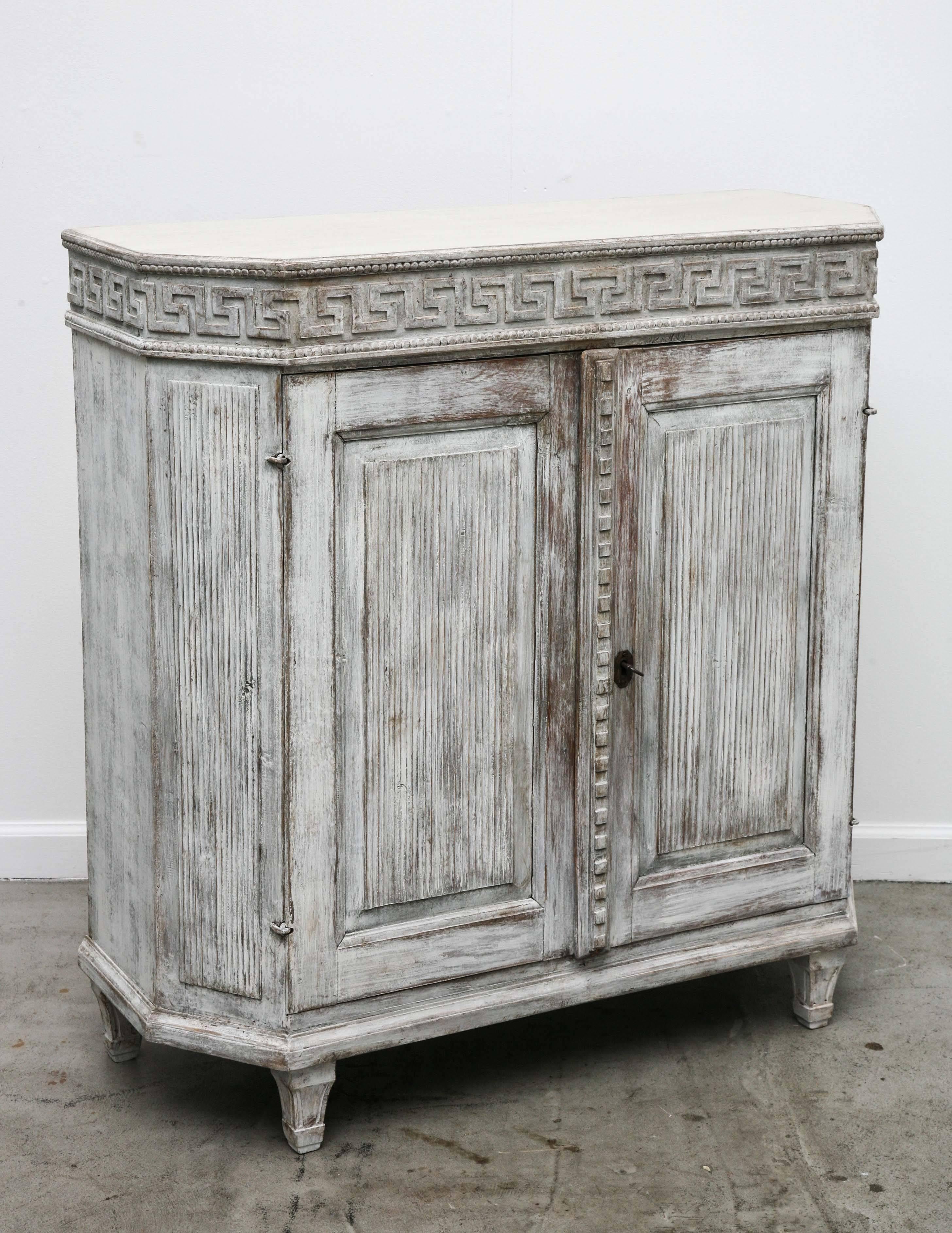 Antique Swedish Gustavian painted small sideboard, carved beaded border and
Greek Key border around top of the cabinet, the door fronts and slanted sides have reeded carved details and a raised moulding with square carving between the doors,
