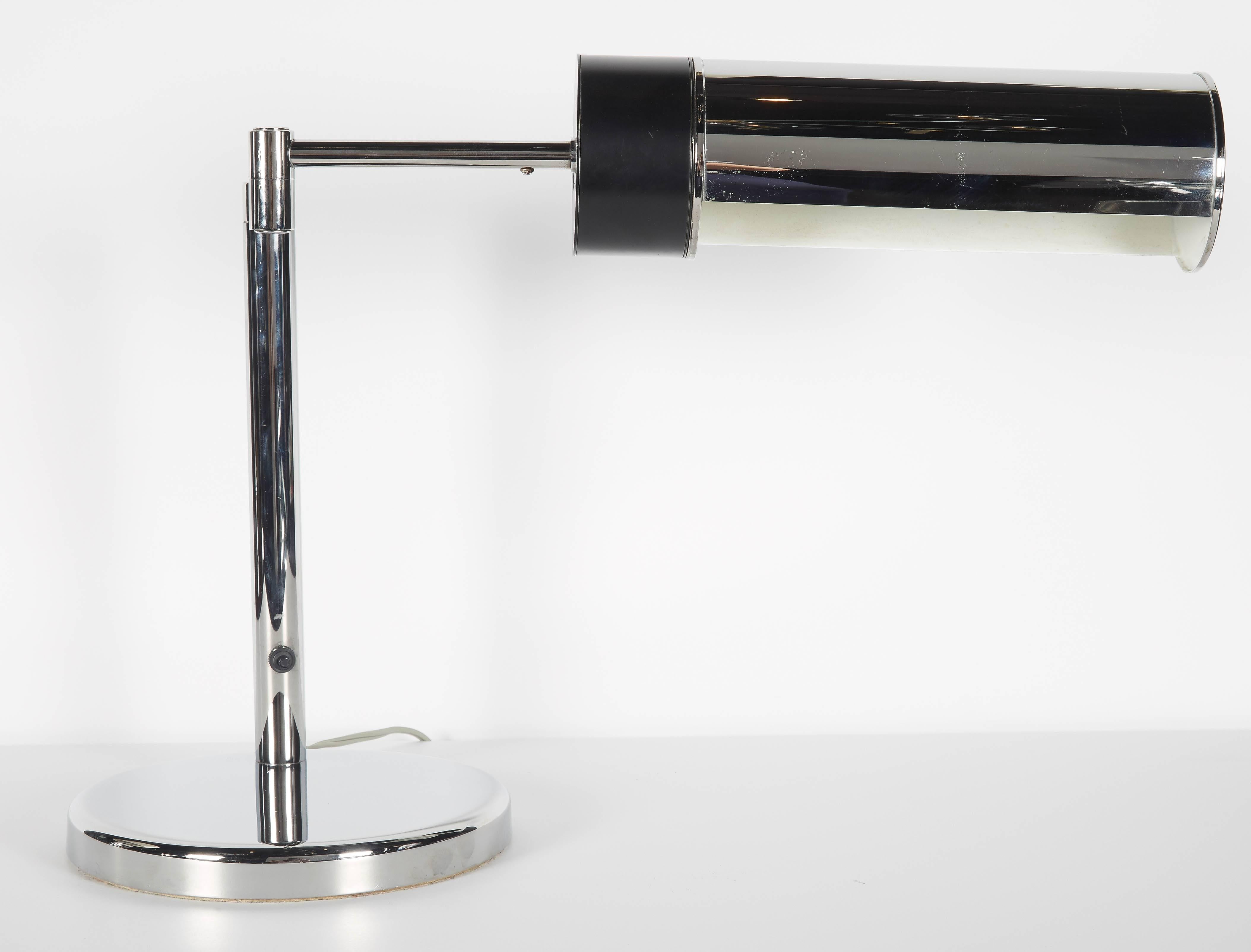 Mid-century modern Walter Von Nessen, Nessen Studio desk lamp with swing arm design and adjustable shade. The lamp has a sleek cylinder design with circular base in polished chrome and the shade features black enameled metal accent. Fitted with
