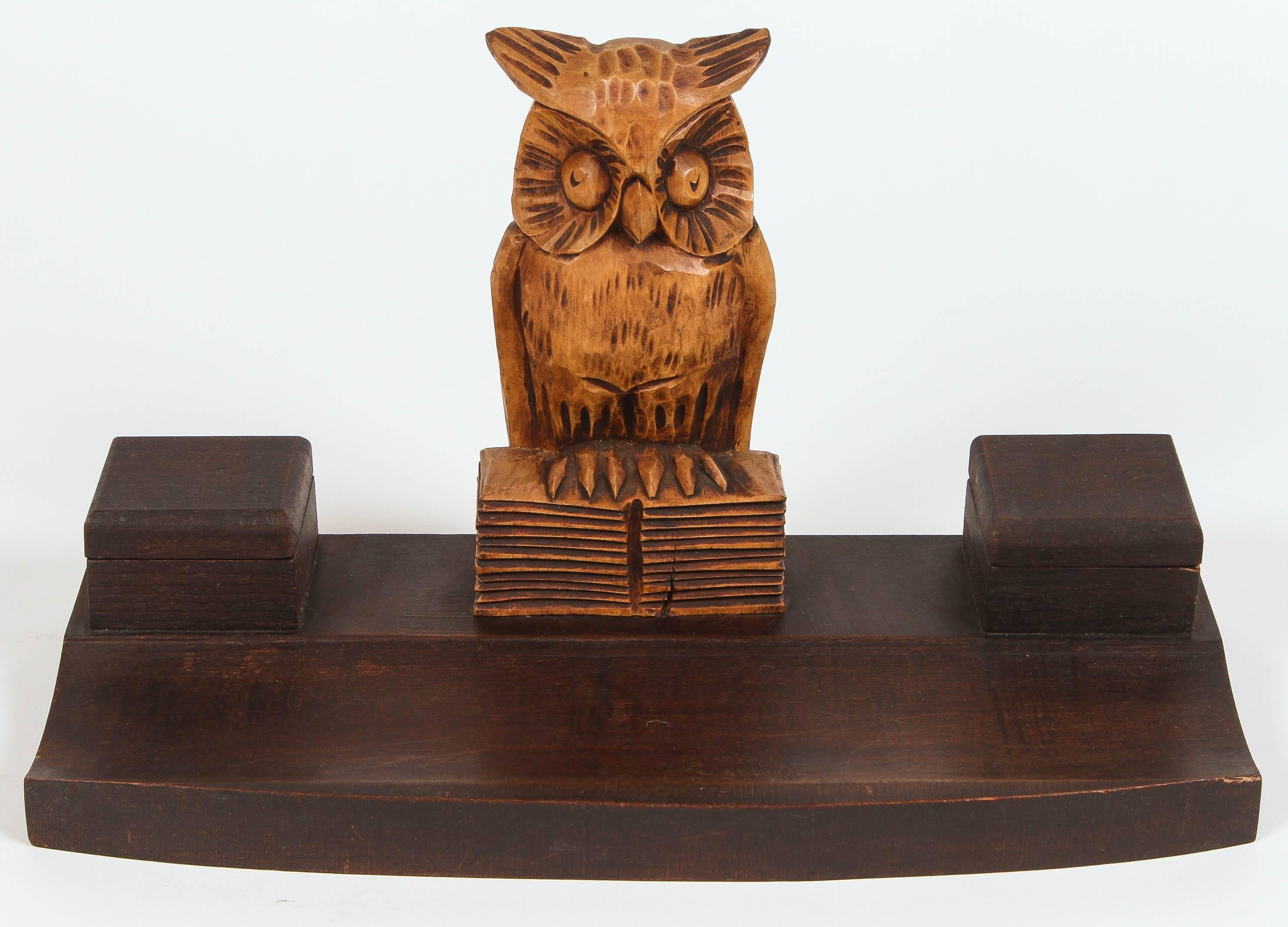 Vintage two-piece carved wooden owl desk set. Main piece features a large owl at the center sitting on a tray, which also has two covered compartments for quill ink, one of which still has the original porcelain insert. Second piece has a smaller
