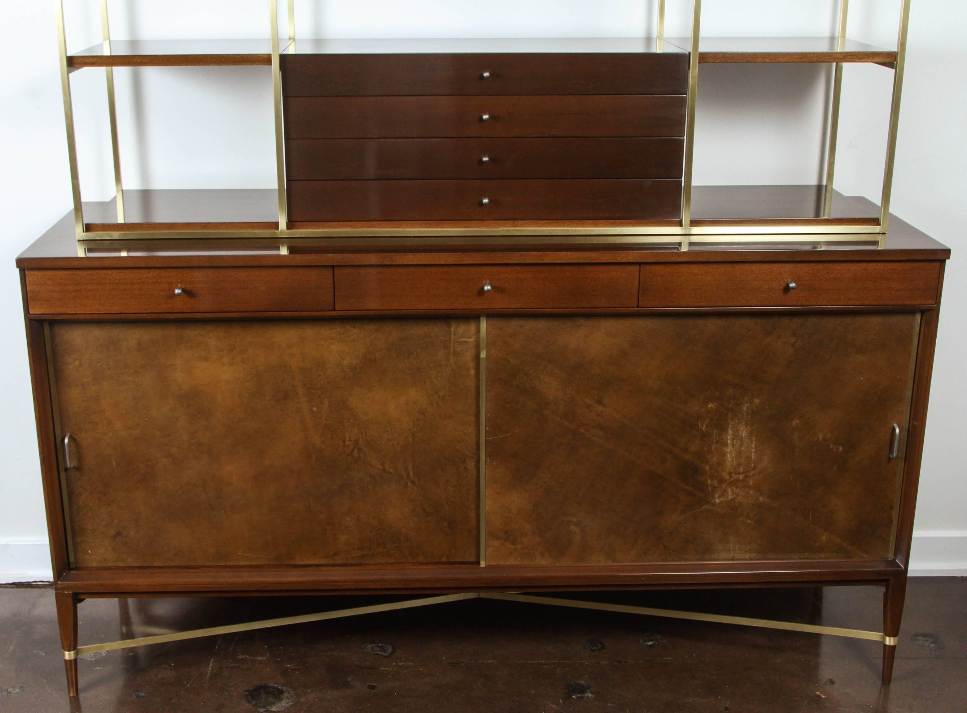 Handsome credenza with wall unit by Paul McCobb for the Calvin Group.

Leather doors and polished brass supports. Exceptional condition. Original tags inside drawers.