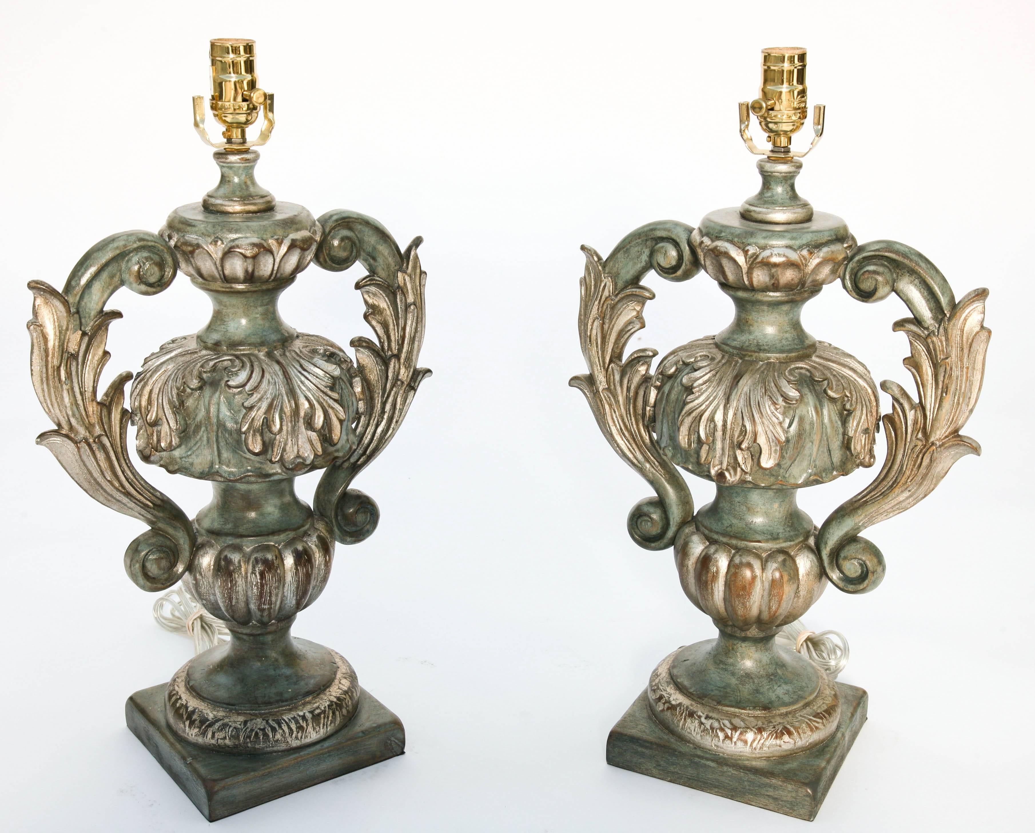 Pair of lamps, painted and parcel silver gilt finish, each an urn-form, with elaborate foliate-carved, scrolling handles, raised on fluted socle, and round foot on a square base.

Stock ID: D9373