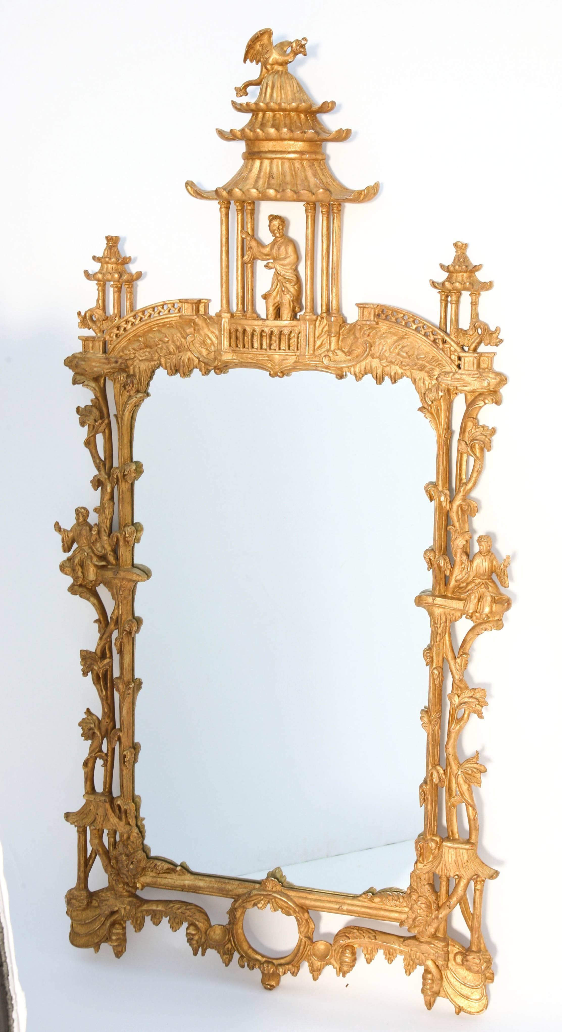 Opposing pair of mirrors, of carved giltwood in the George III style, its mirror set within a shaped frame incorporating symmetrical leafy vines, each sides hung with figural carving, surmounted by an pierced pediment, elaborately carved with