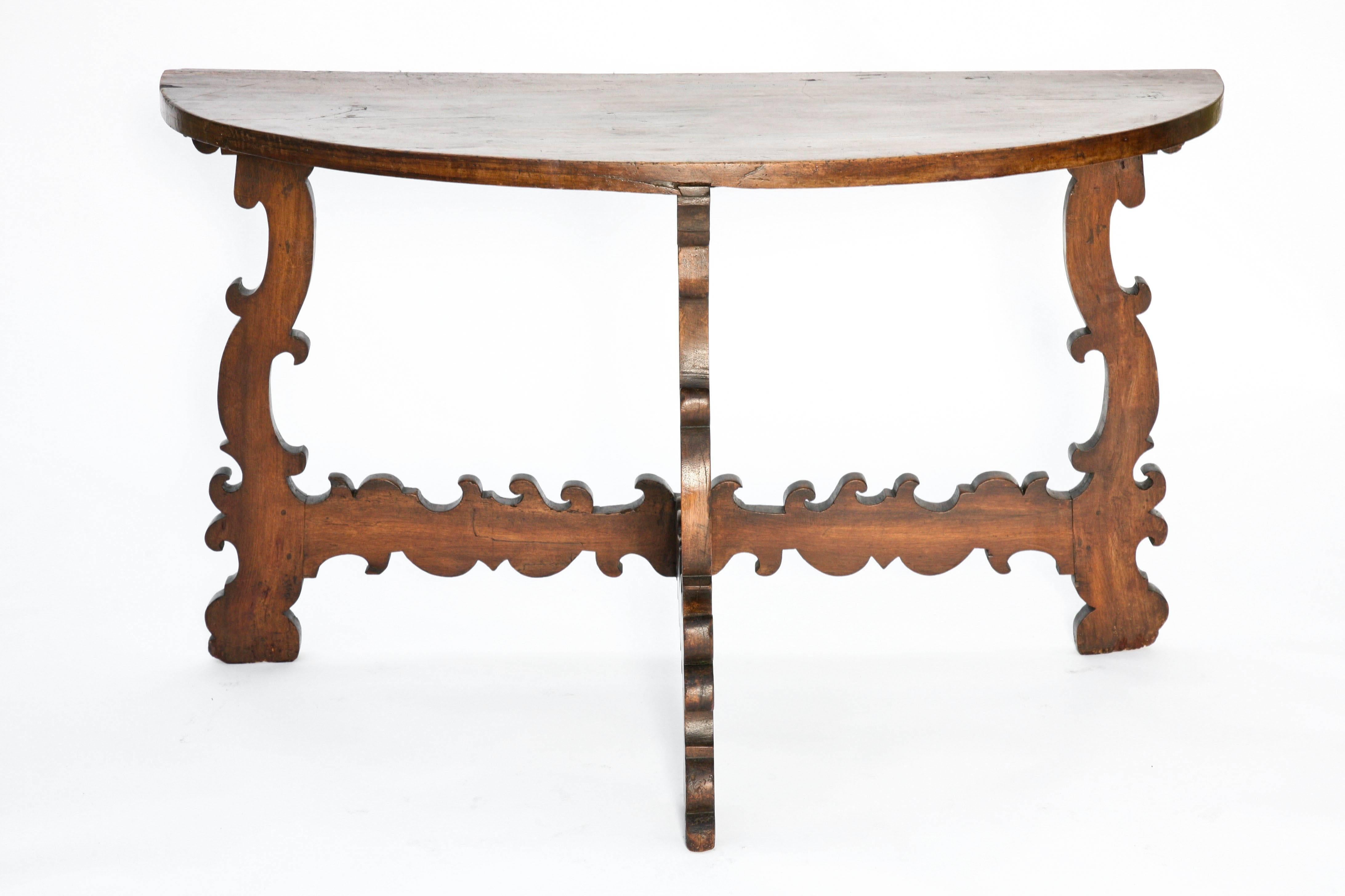 Console table, of walnut, having demilune shaped top supported by wonderfully carved scrolling legs and stretchers.