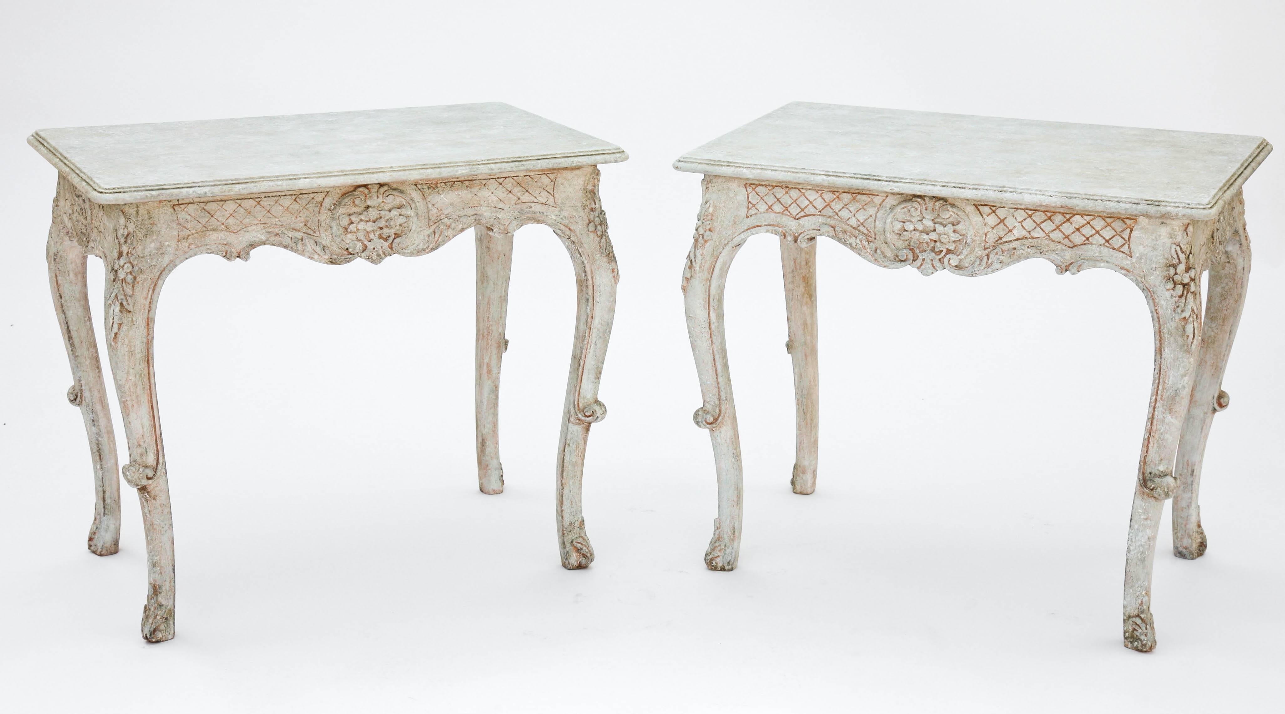 Pair of end tables, each having a painted finish, rectangular molded top on crosshatched, in-carved apron, centered by foliate cartouche, flanked by acanthus, raised on cabriole legs, with scrolling knees, ending in foliate foot.