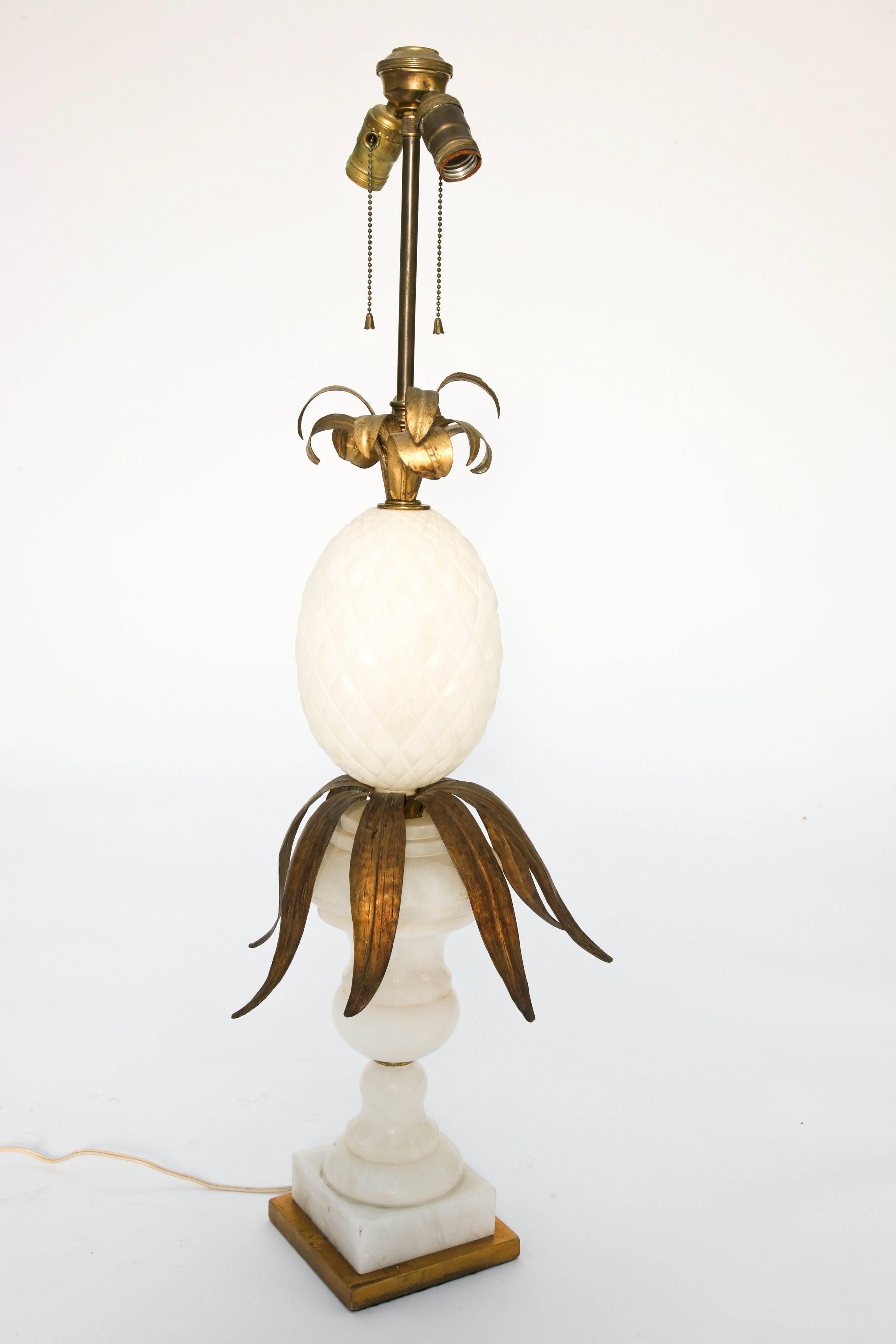 Une seule lampe, en albâtre sculpté, ayant une base en forme d'urne, remplie d'un grand ananas avec des feuilles en fer doré, sur la base carrée.

Stock ID : D9340