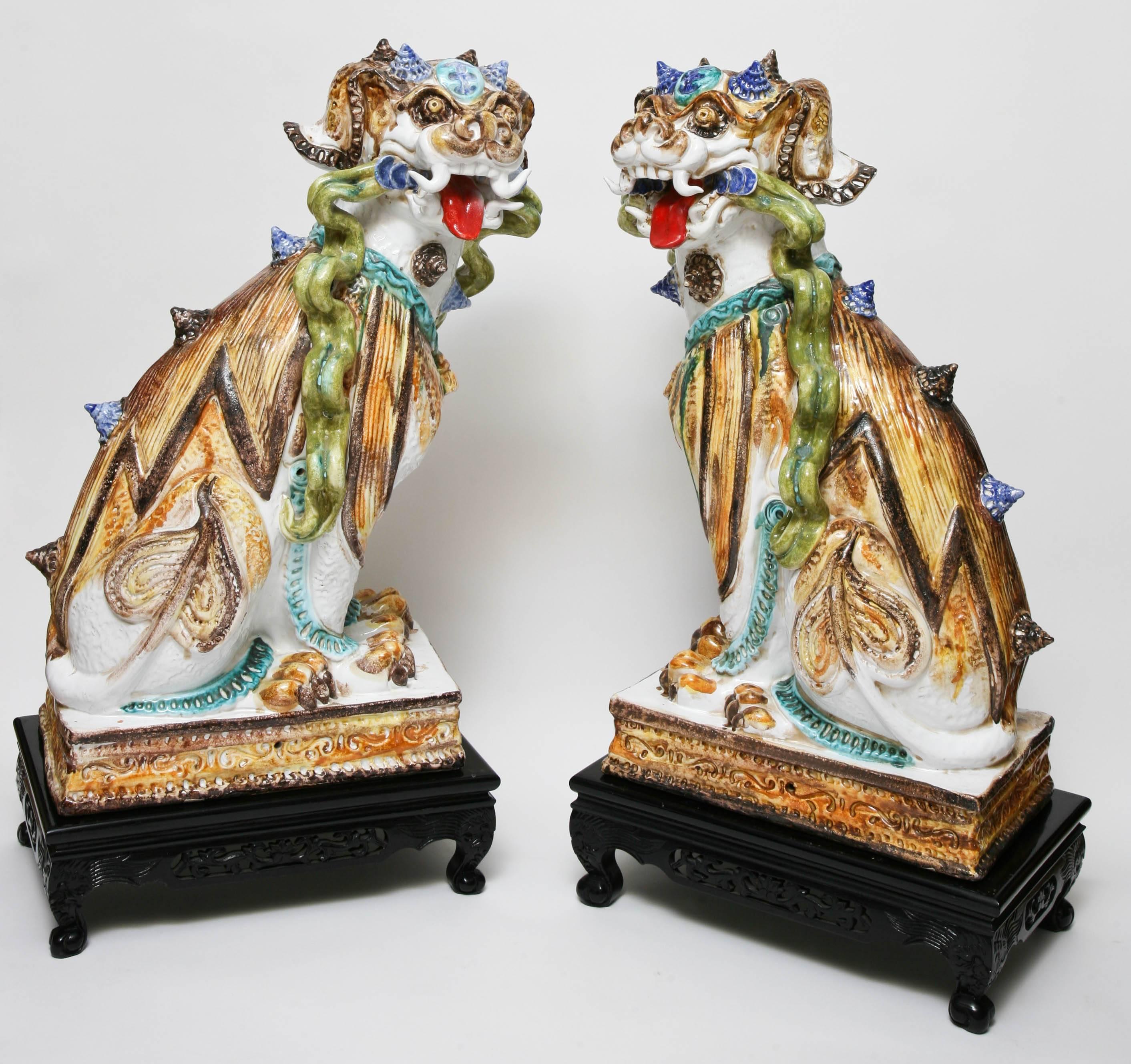 Fabulous pair of large multicolored glazed terra cotta foo dogs on bases.