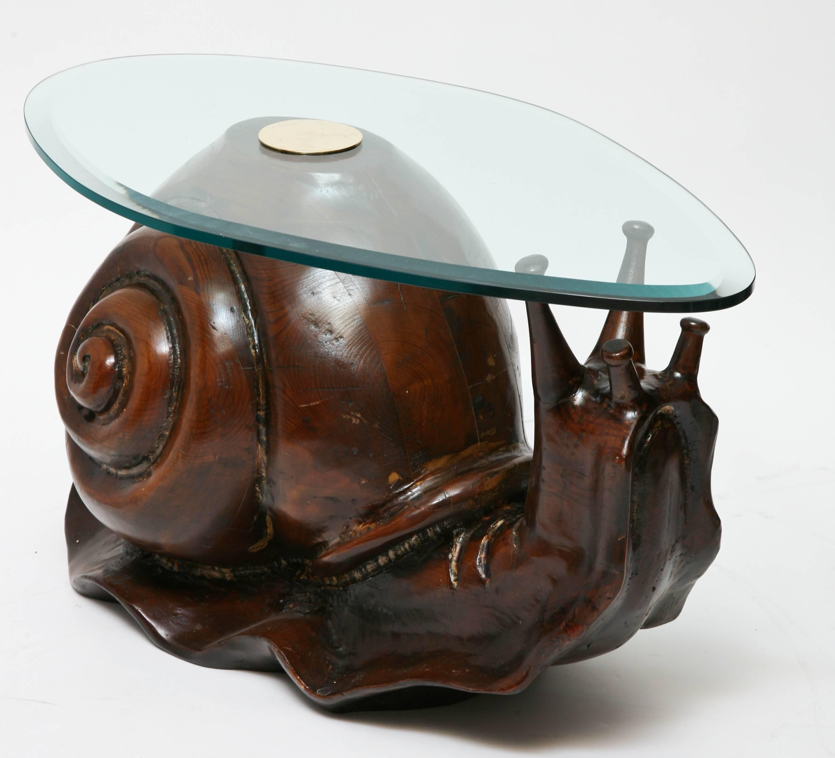Whimsical carved dark wood snail sculpture with glass top for use as coffee or side table.