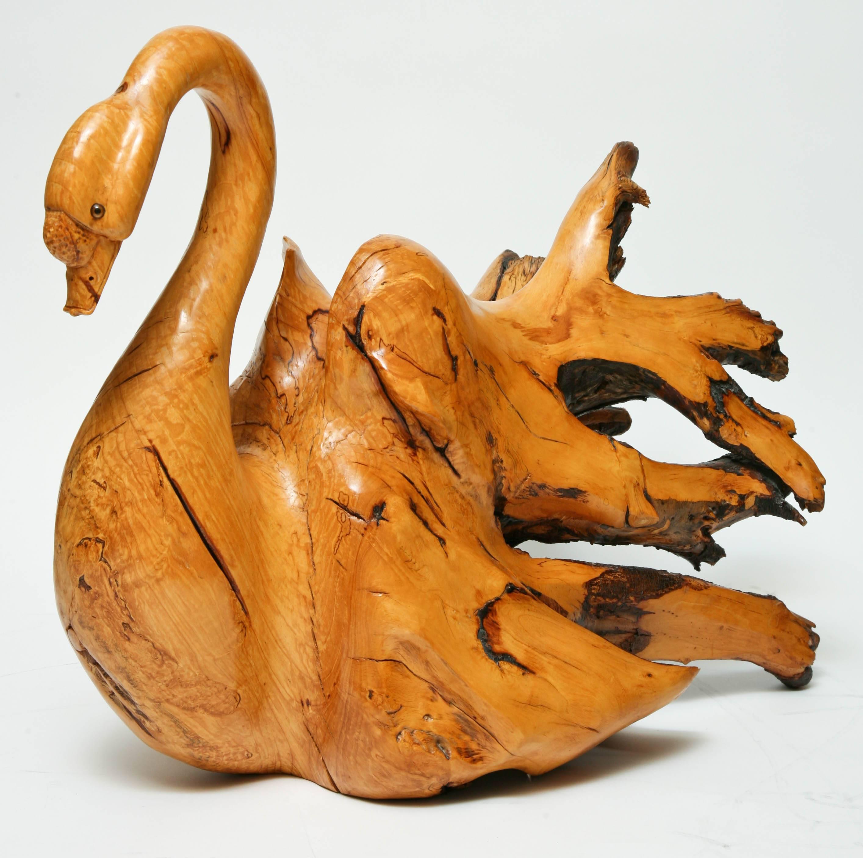 Striking driftwood sculpture of a graceful swan with glass eyes.