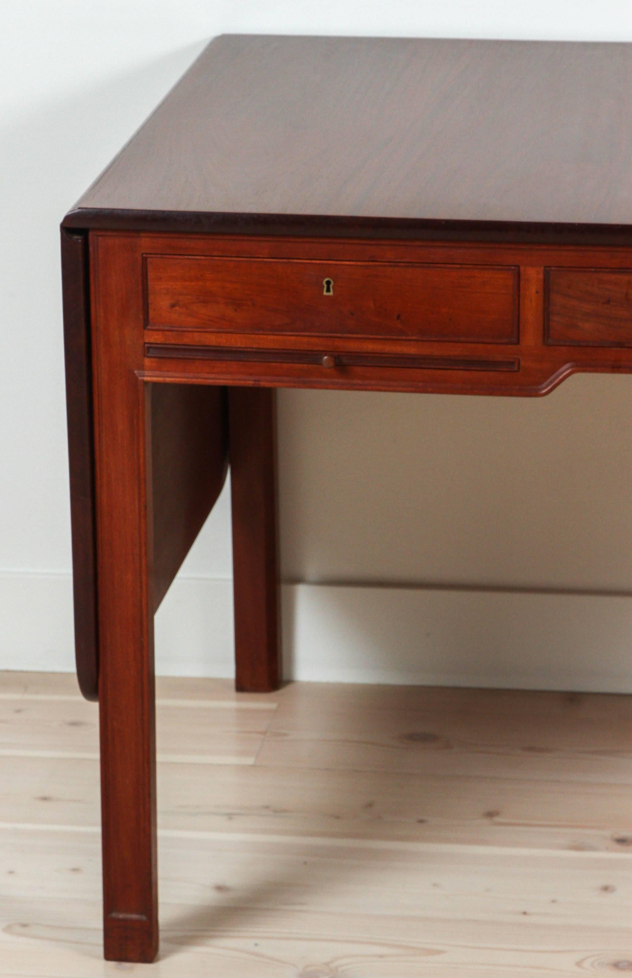 Mahogany desk model 4155 by Kaare Klint for Rud. Rasmussens Snedkerier,

Denmark, 1930.
Stained Cuban mahogany, brass.
Measures: 60¼ W x 30 D x 28¾ H in.
Desk features three drawers, two pull-out work surfaces and two drop leaves. Desk measures