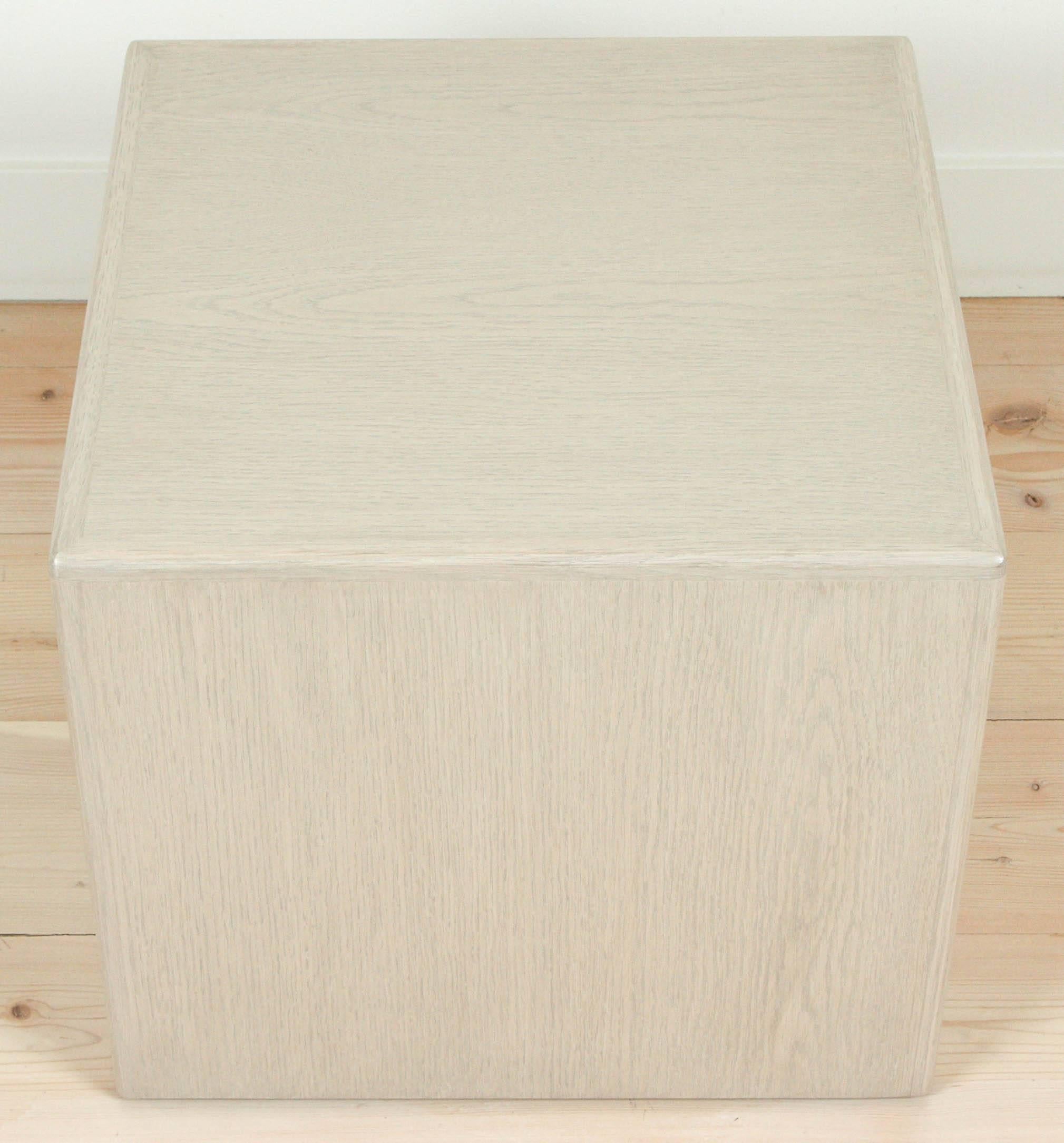 The Wood Cube Table is a cube-shaped side table that is covered on five sides with American Walnut or White Oak with solid wood edge banding and a 3/4″ floating inset base. This pair pictured in Whitewashed Oak.

Available to order in various