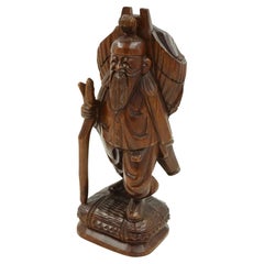Vintage Asian Carved Figure of a Man with Pack and Walking Stick (Figure asiatique sculptée d'un homme avec un sac à dos et une canne)