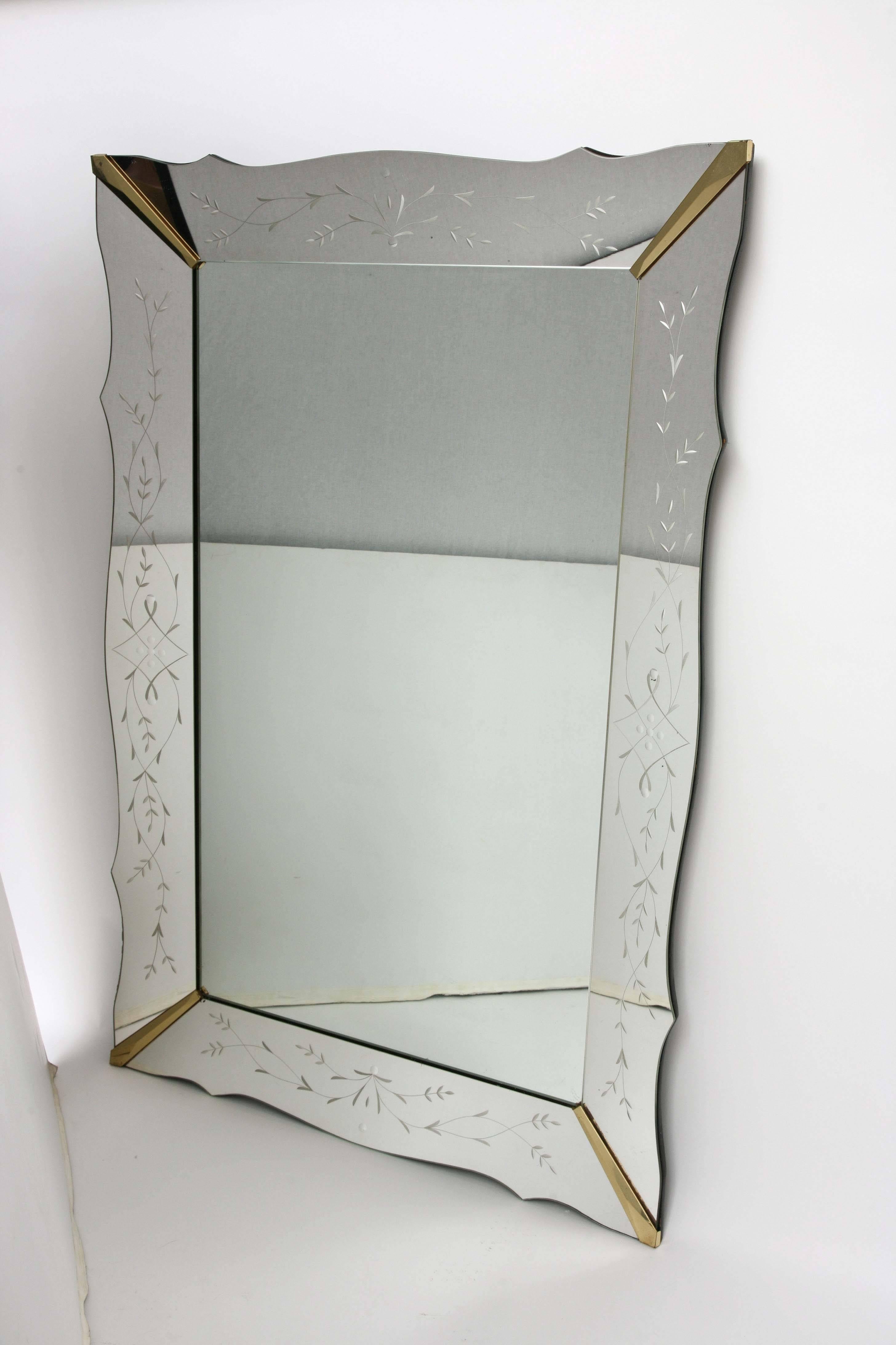 Very large Venetian style mirror with scalloped edge. Flower etching on the mirrored side panels separated by brass corner beads.