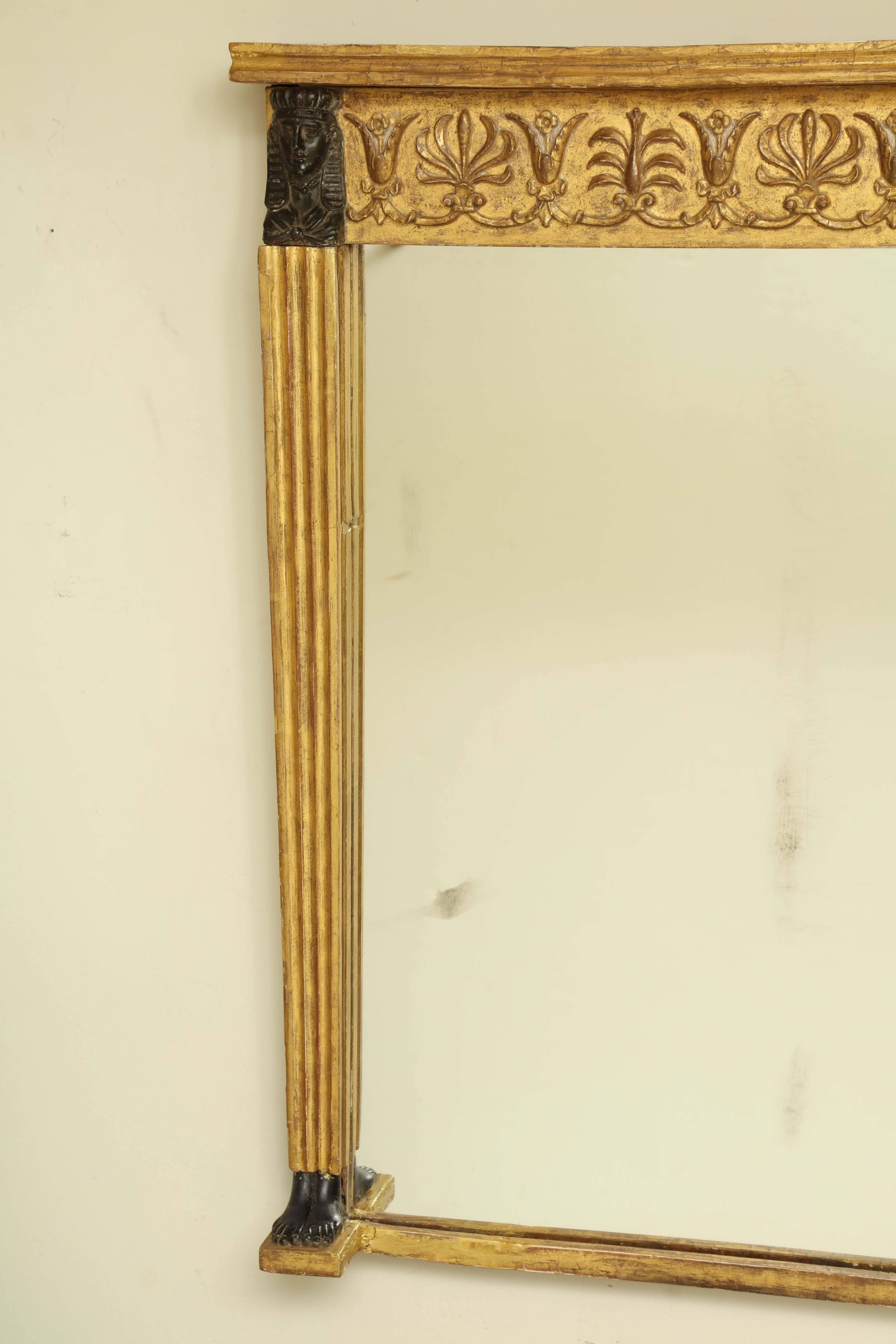 Unusual pair of Regency carved gilt and ebonized overmantel mirrors.