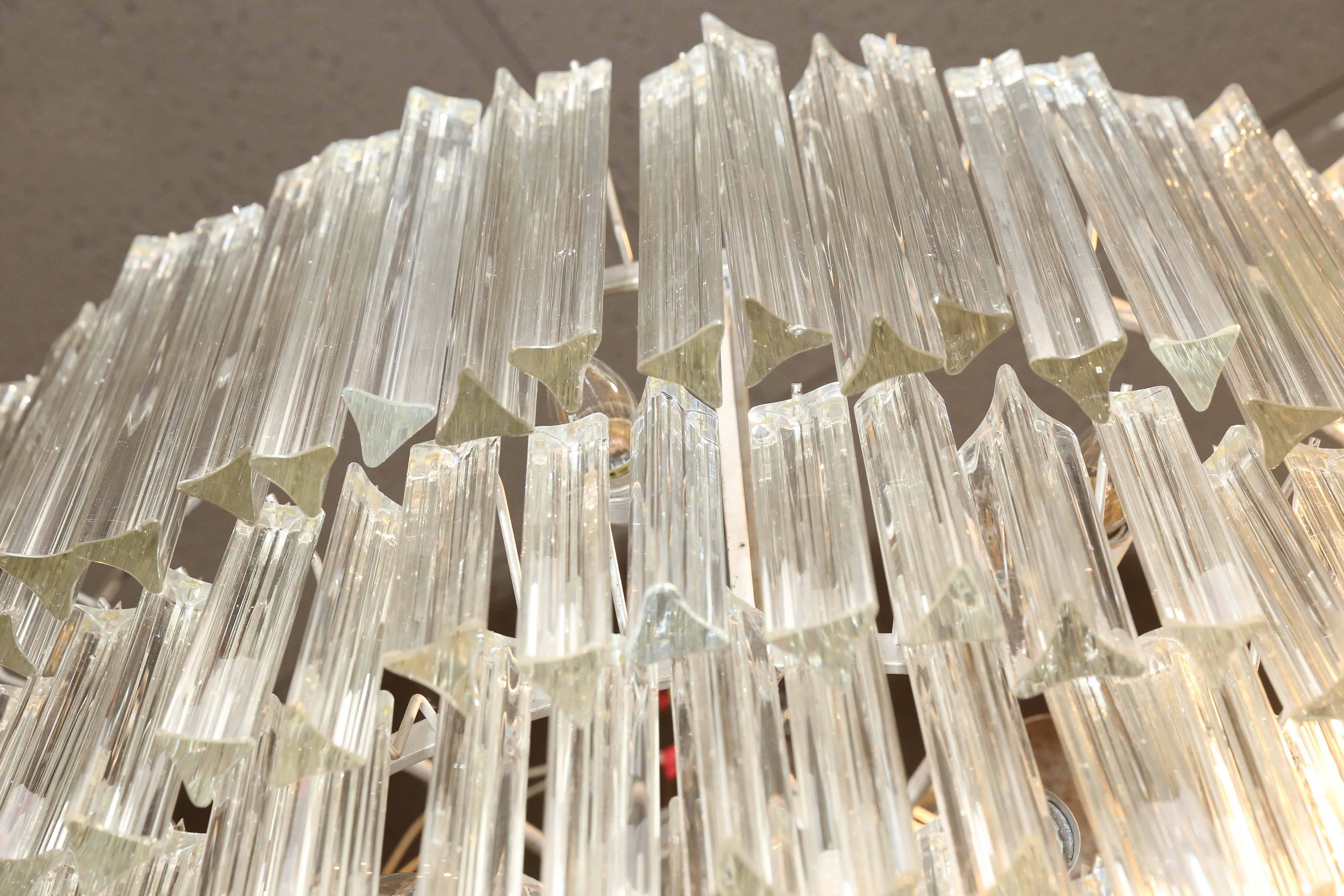An Italian Murano glass chandelier with cascading tiers of Venetian glass.
An elegant fixture with faceted glass prisms. This fixture has glass rods that 
are suspended from a silver colored metal form. This is attributed to Paolo
Venini