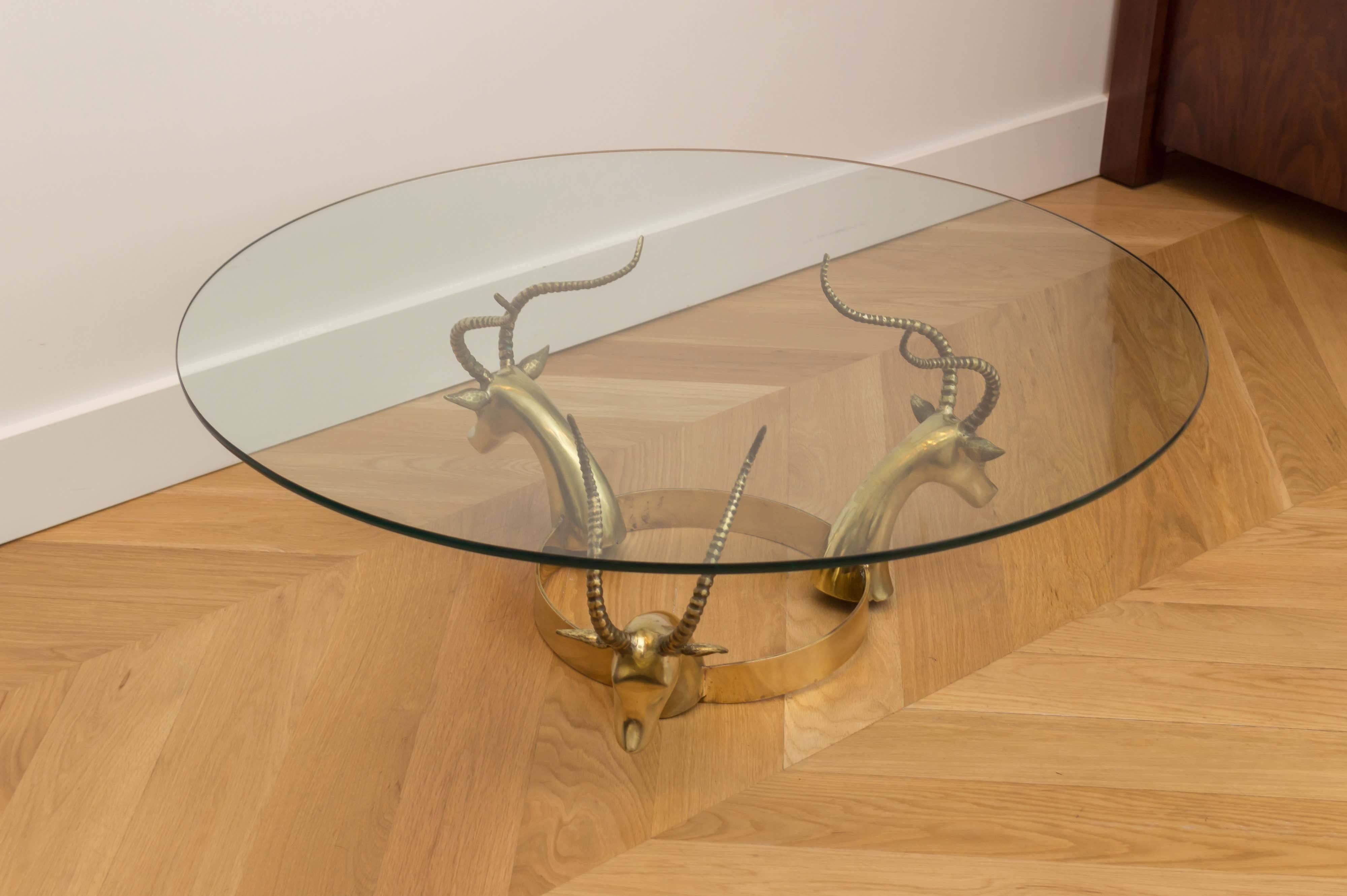 Brass gazelle glass top cocktail table.