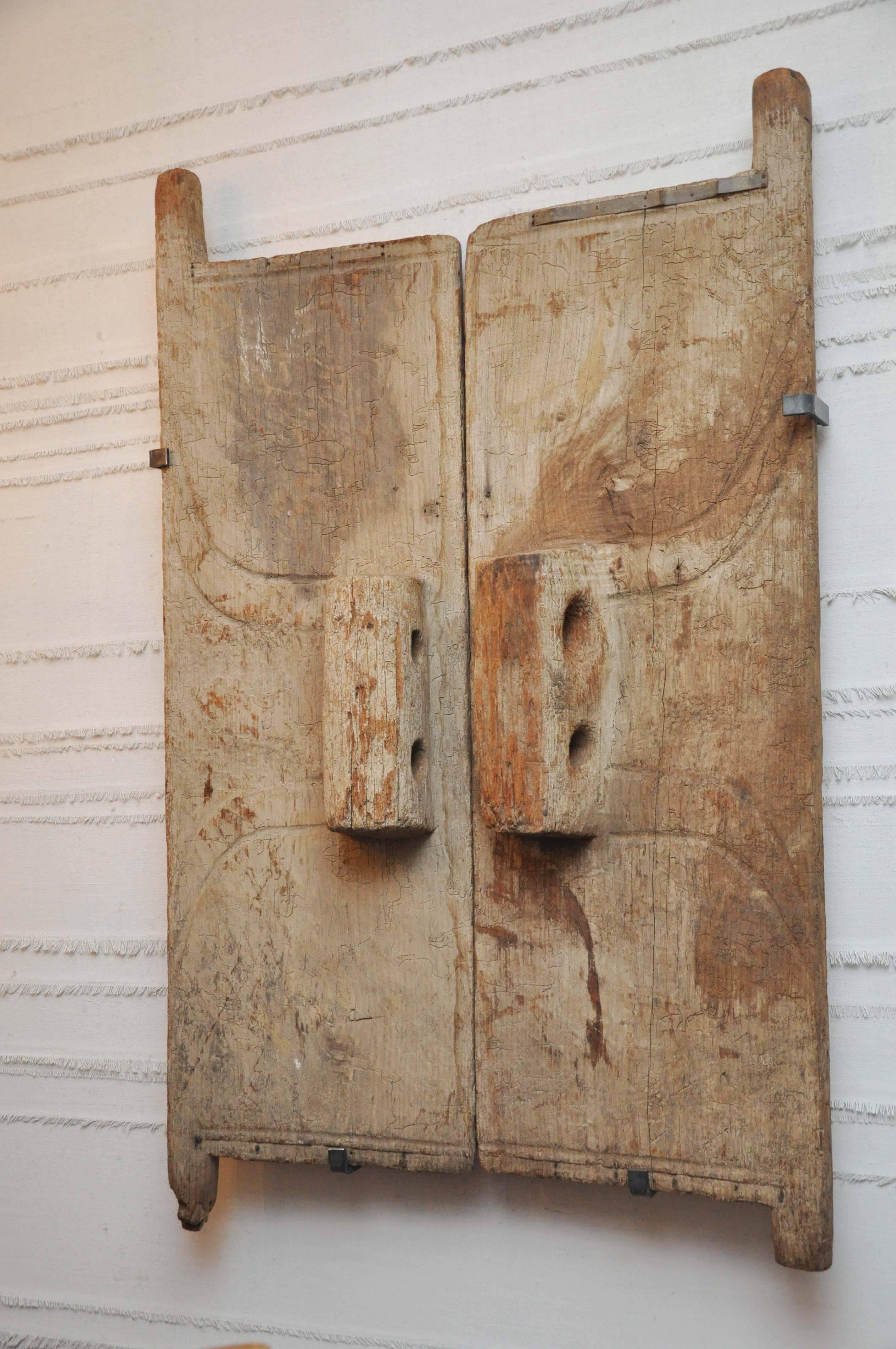 18th century Naga Granary Doors. These handsome and hefty granary doors were found in Nagaland. They were originally situated at the entrance to a granary. The buildings were short, hence the scale of the doors. 

the hanging apparatus is not